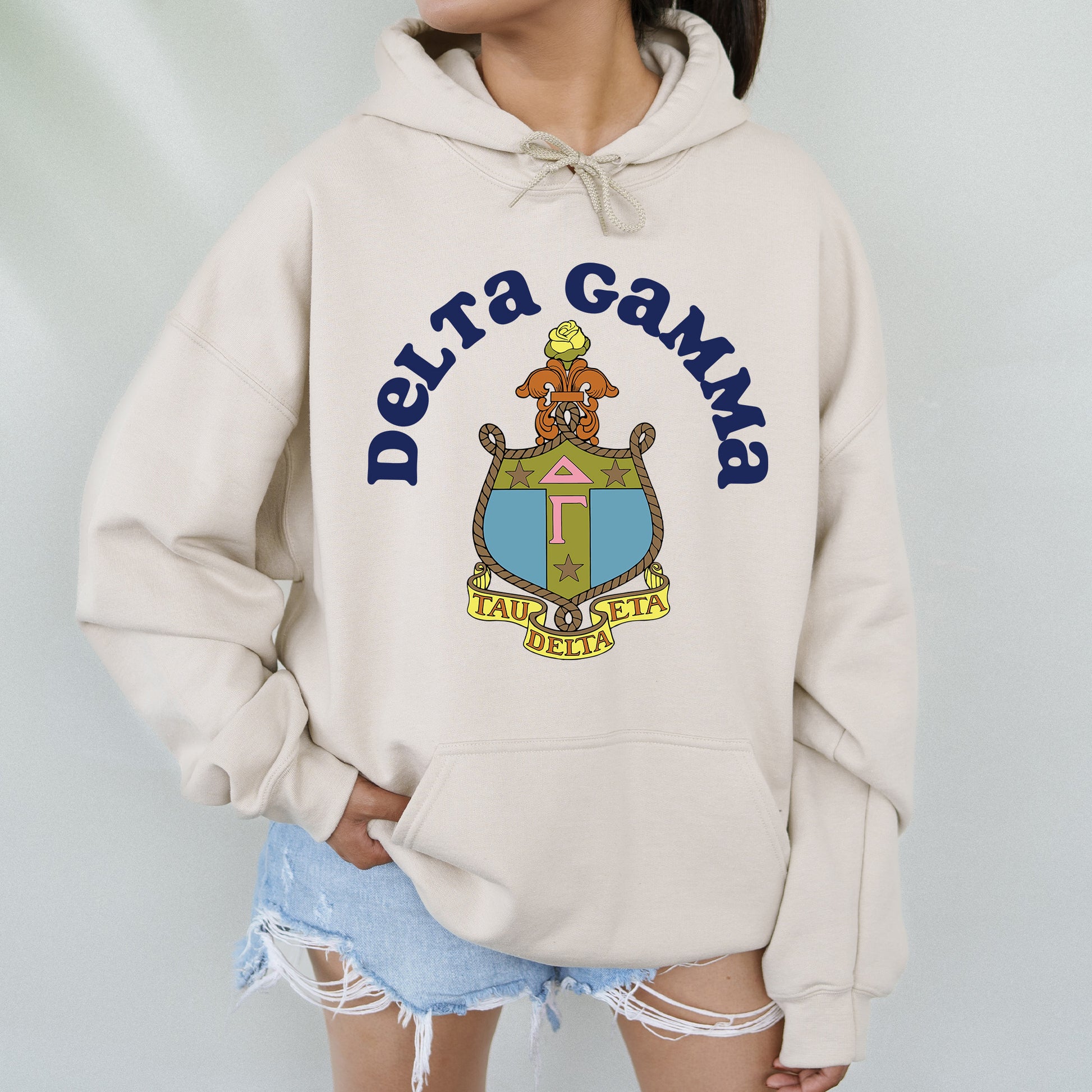 a woman wearing a white sweatshirt with the words delta gama on it