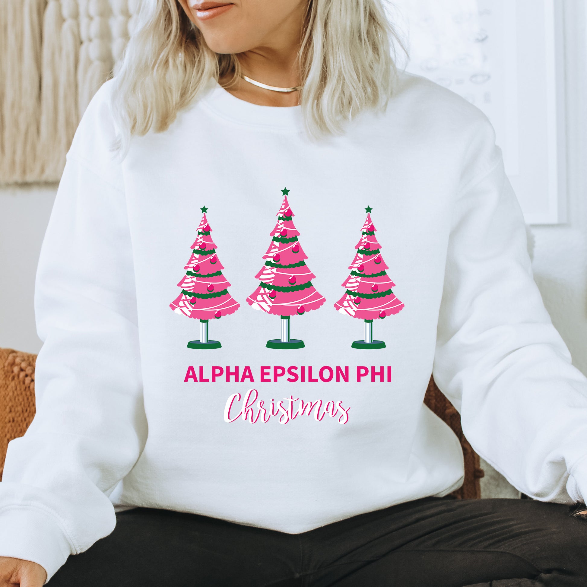 a woman wearing a white sweatshirt with pink trees on it
