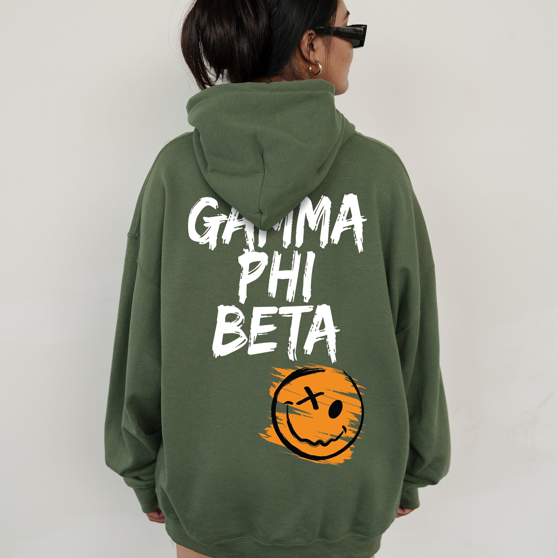 a woman wearing a green hoodie with a smiley face on it