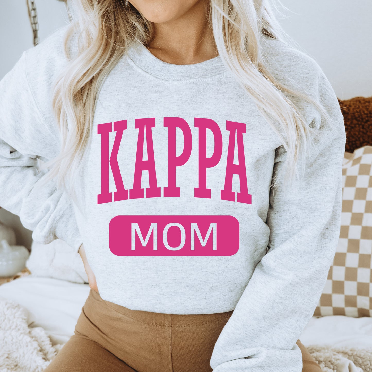 a woman wearing a sweatshirt that says kappa mom