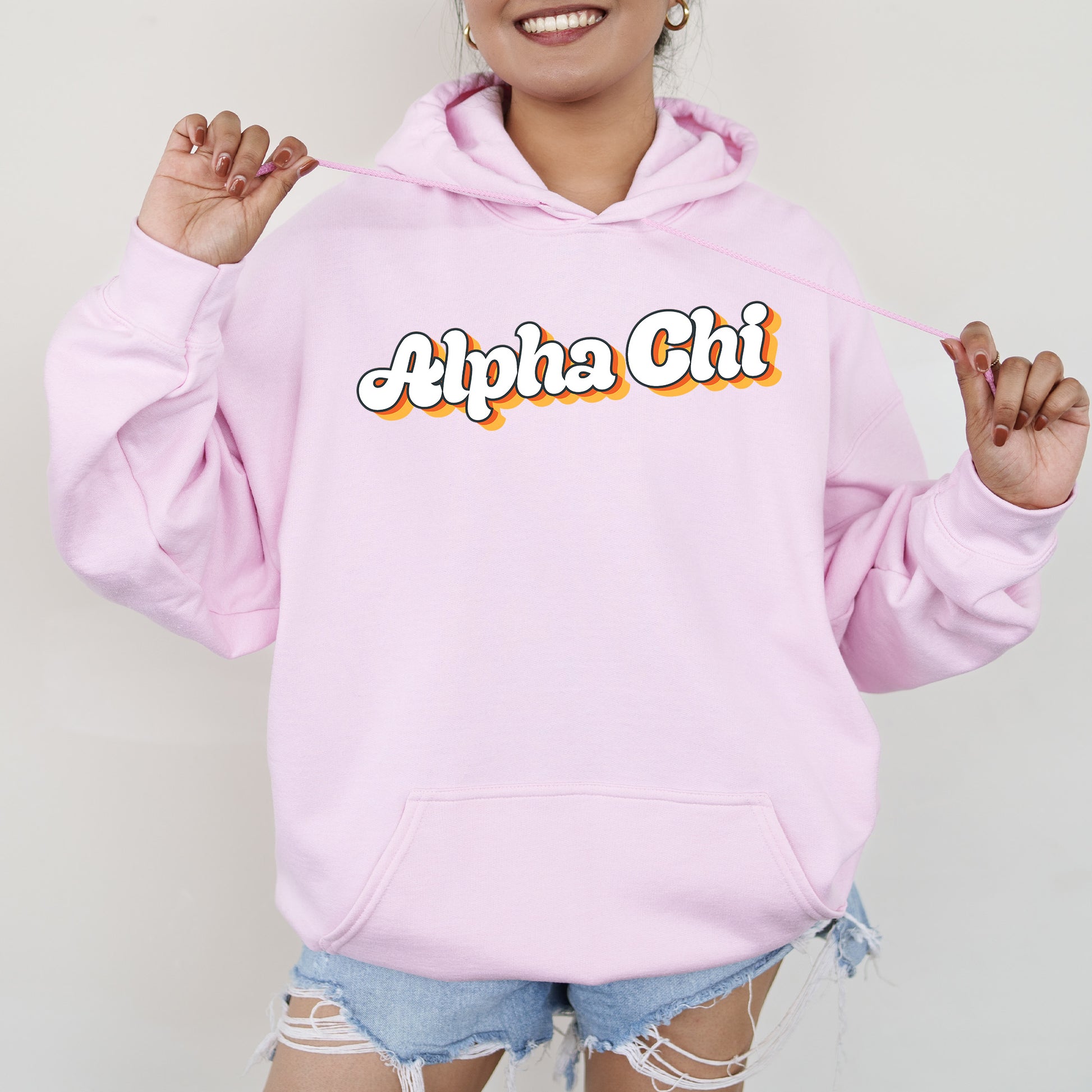 a woman wearing a pink hoodie with the word hipa chi on it