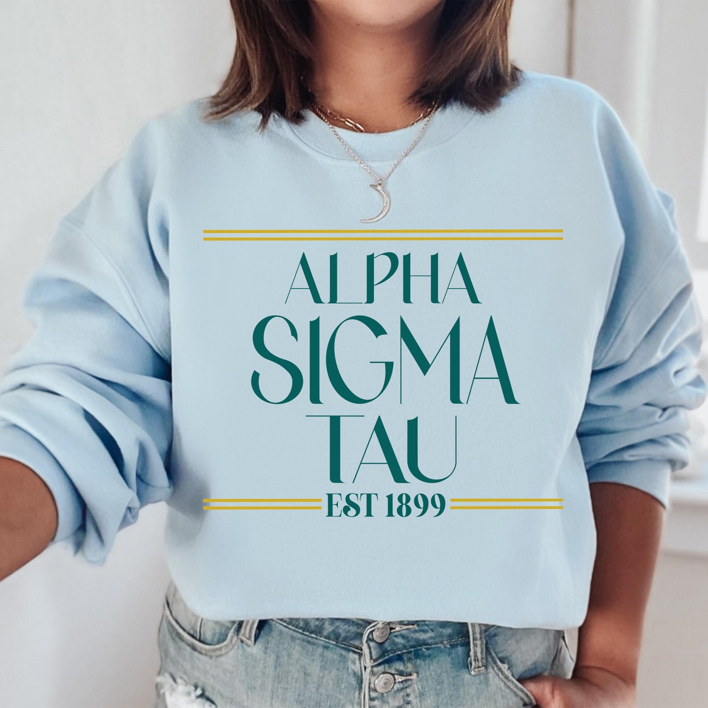 a woman wearing a blue sweatshirt with the words, alpha sigma tau est