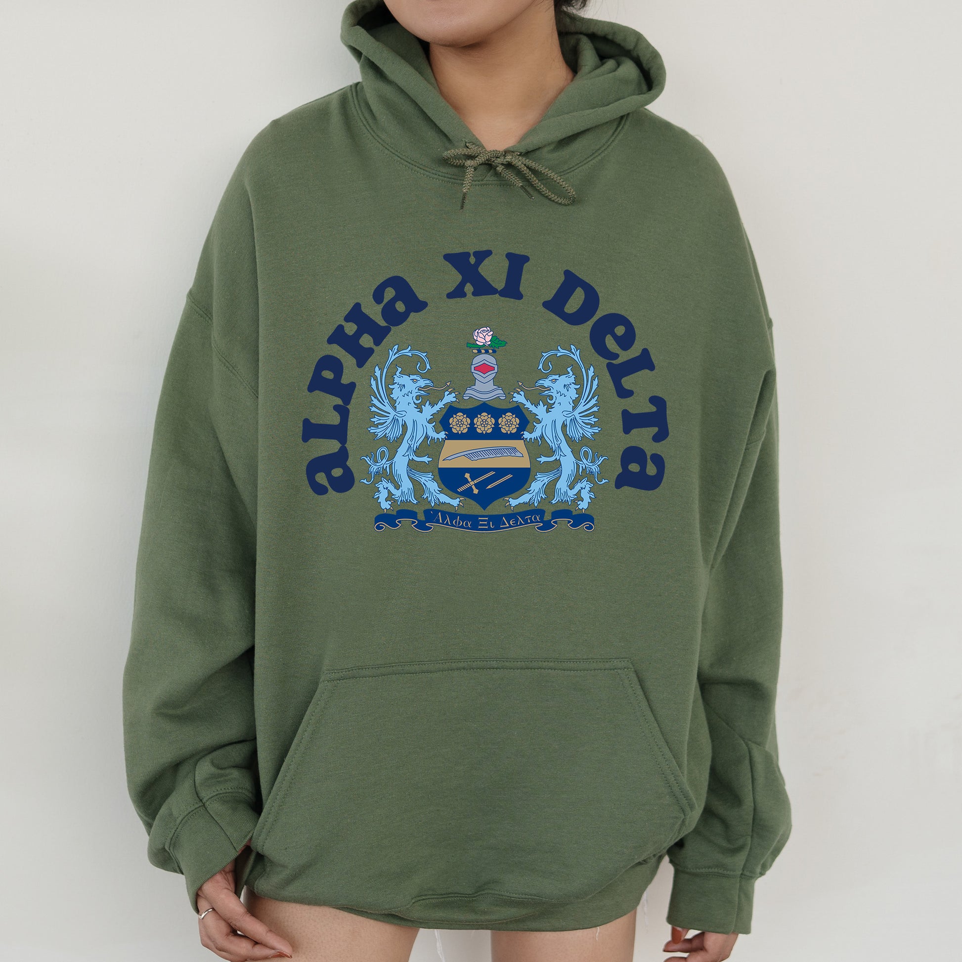 a person wearing a green hoodie with a crest on it