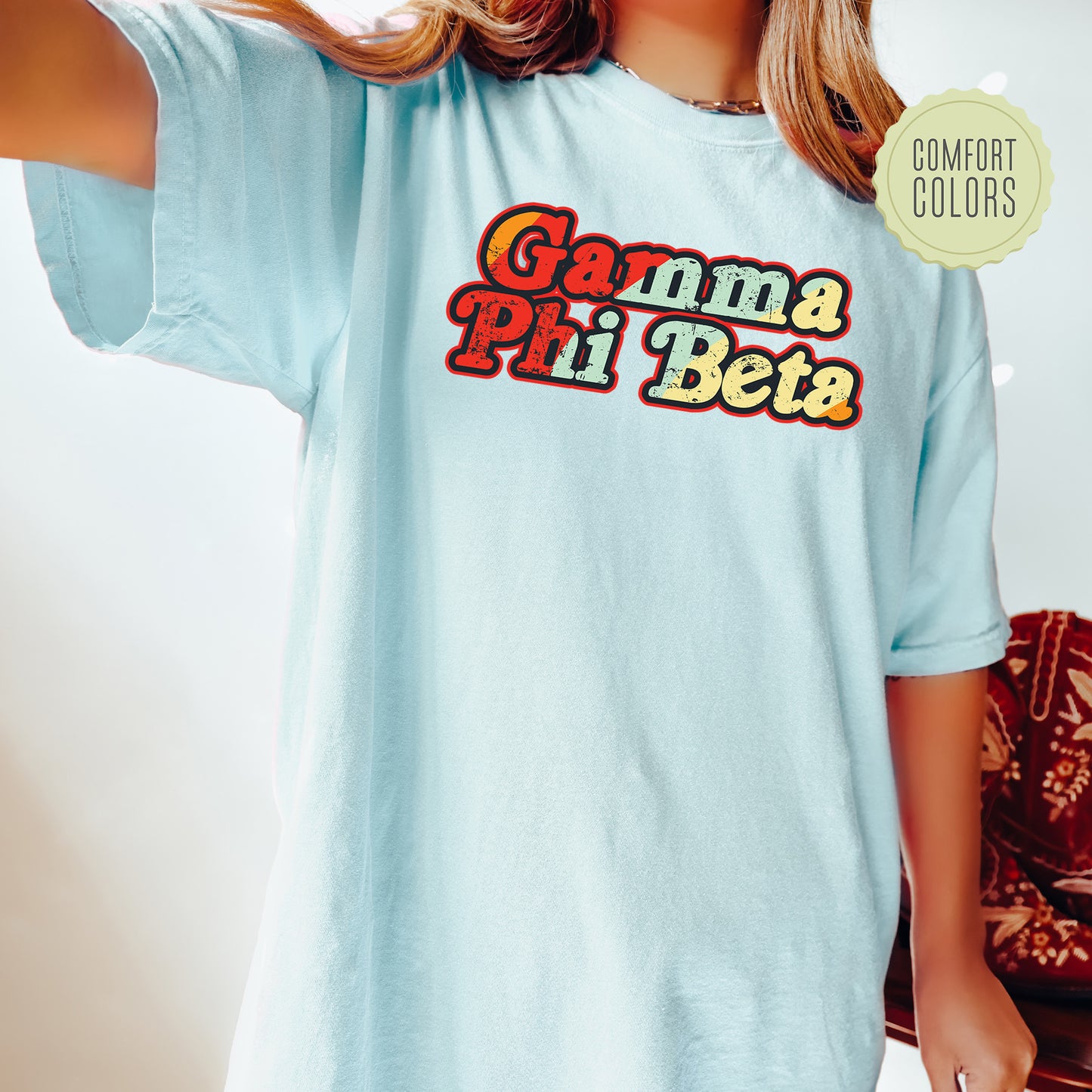 a woman wearing a light blue shirt with the words gama pi pi beta