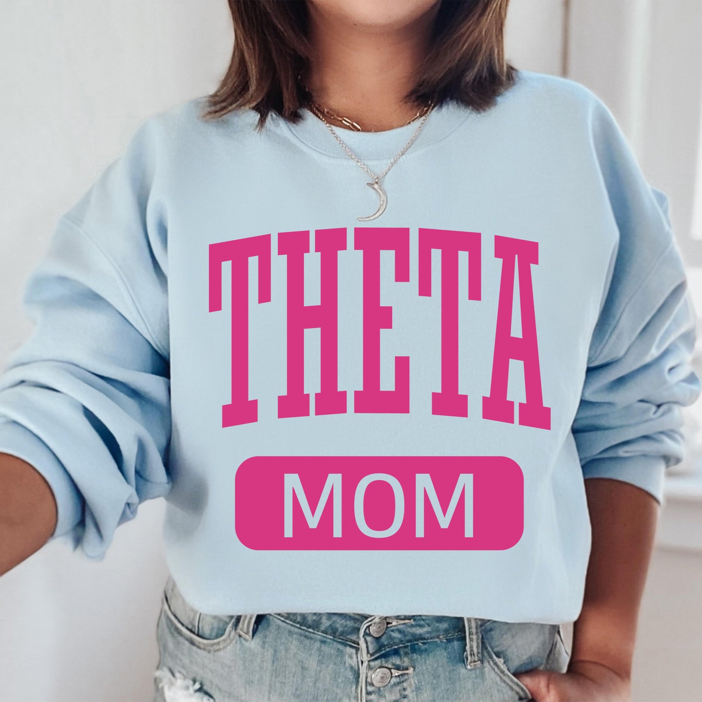 a woman wearing a sweatshirt that says,'theata mom '