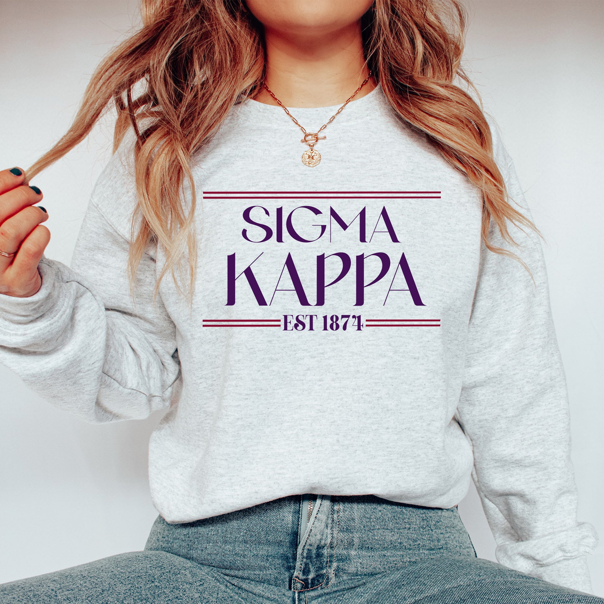 a woman wearing a sweater that says signa kappa