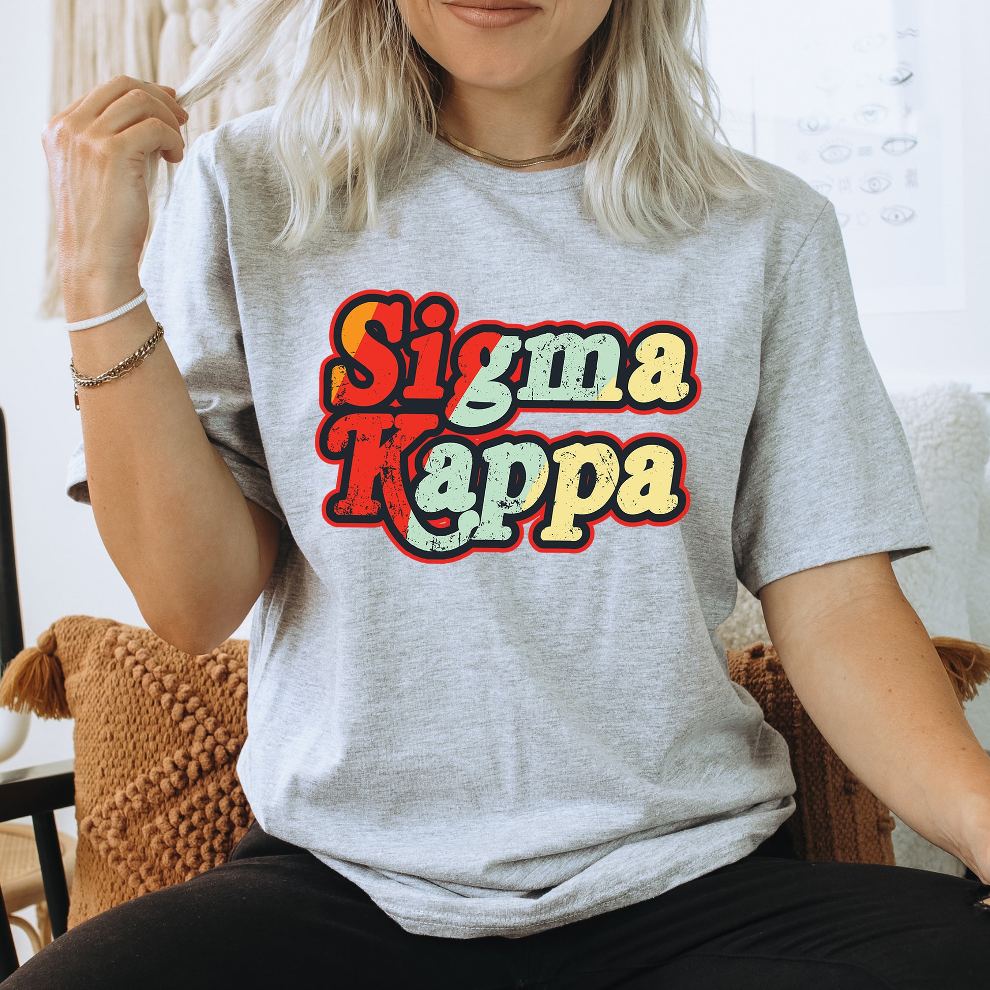 a woman sitting on a chair wearing a shirt that says stigmaa kappa