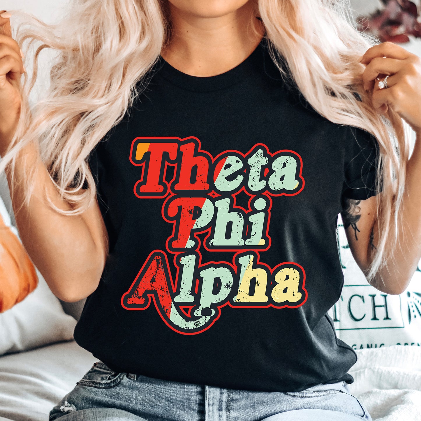 a woman wearing a black shirt that says thea phi aloha