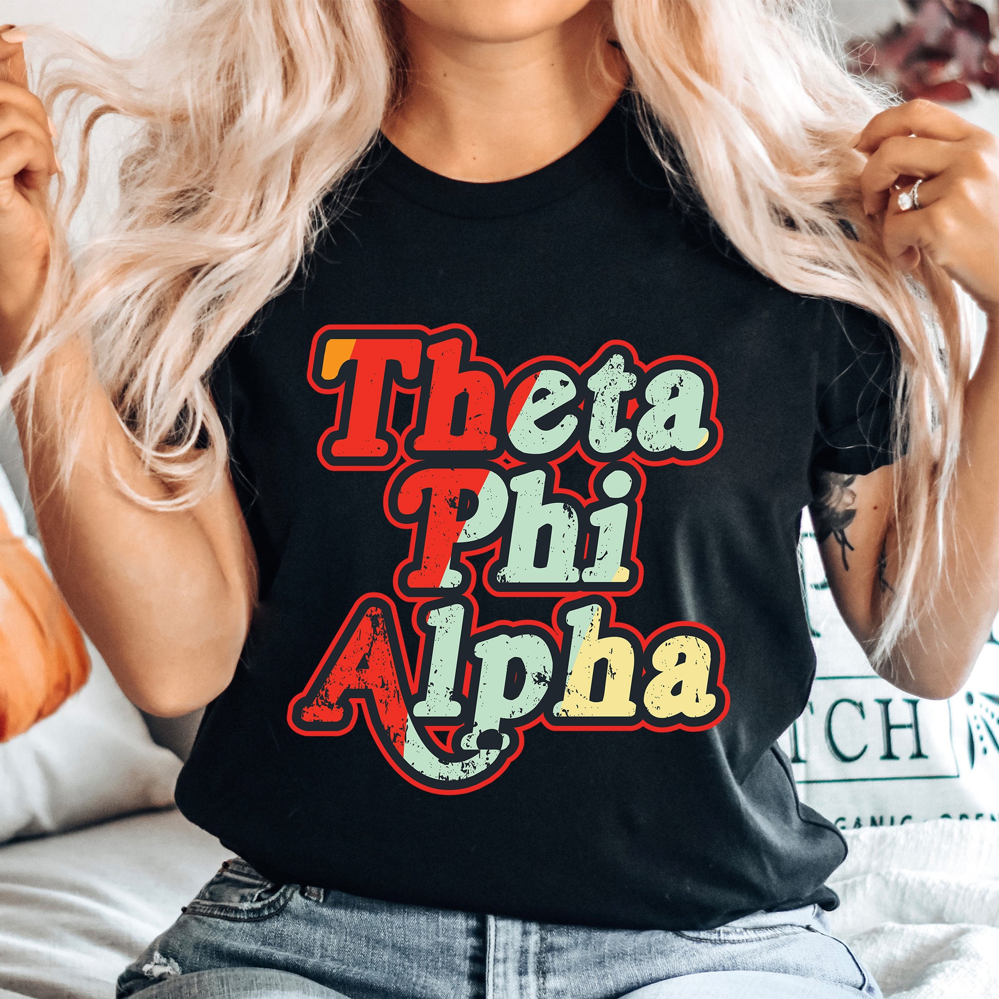 a woman wearing a black shirt that says thea phi aloha