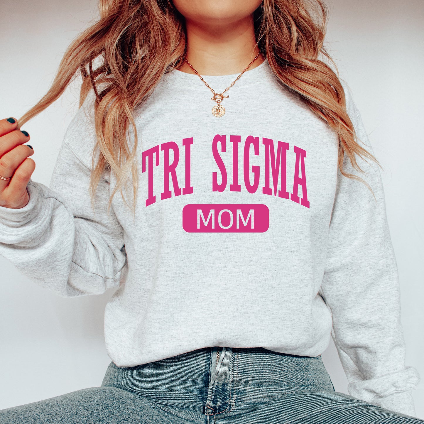 a woman wearing a sweatshirt that says tri stigma mom