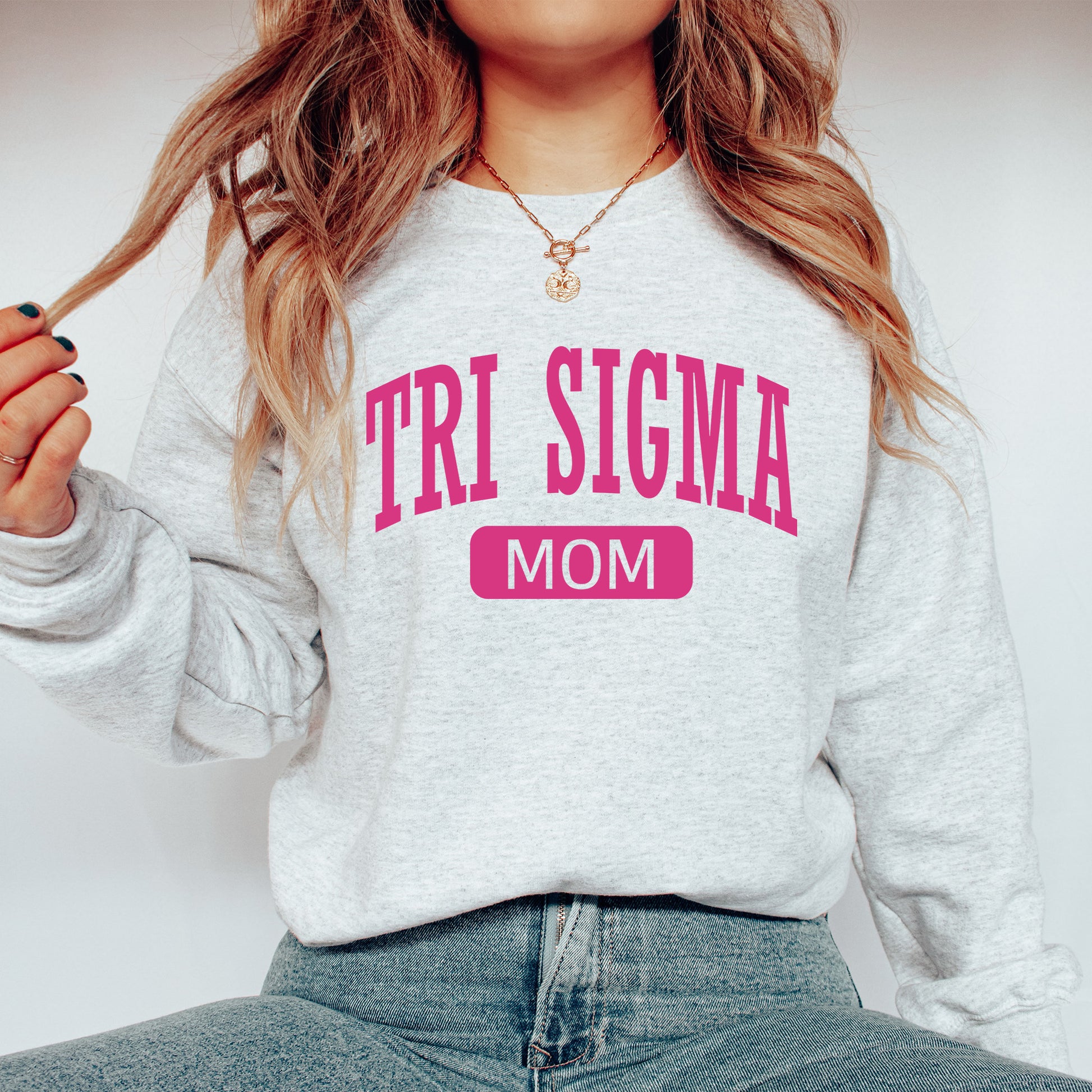 a woman wearing a sweatshirt that says tri stigma mom