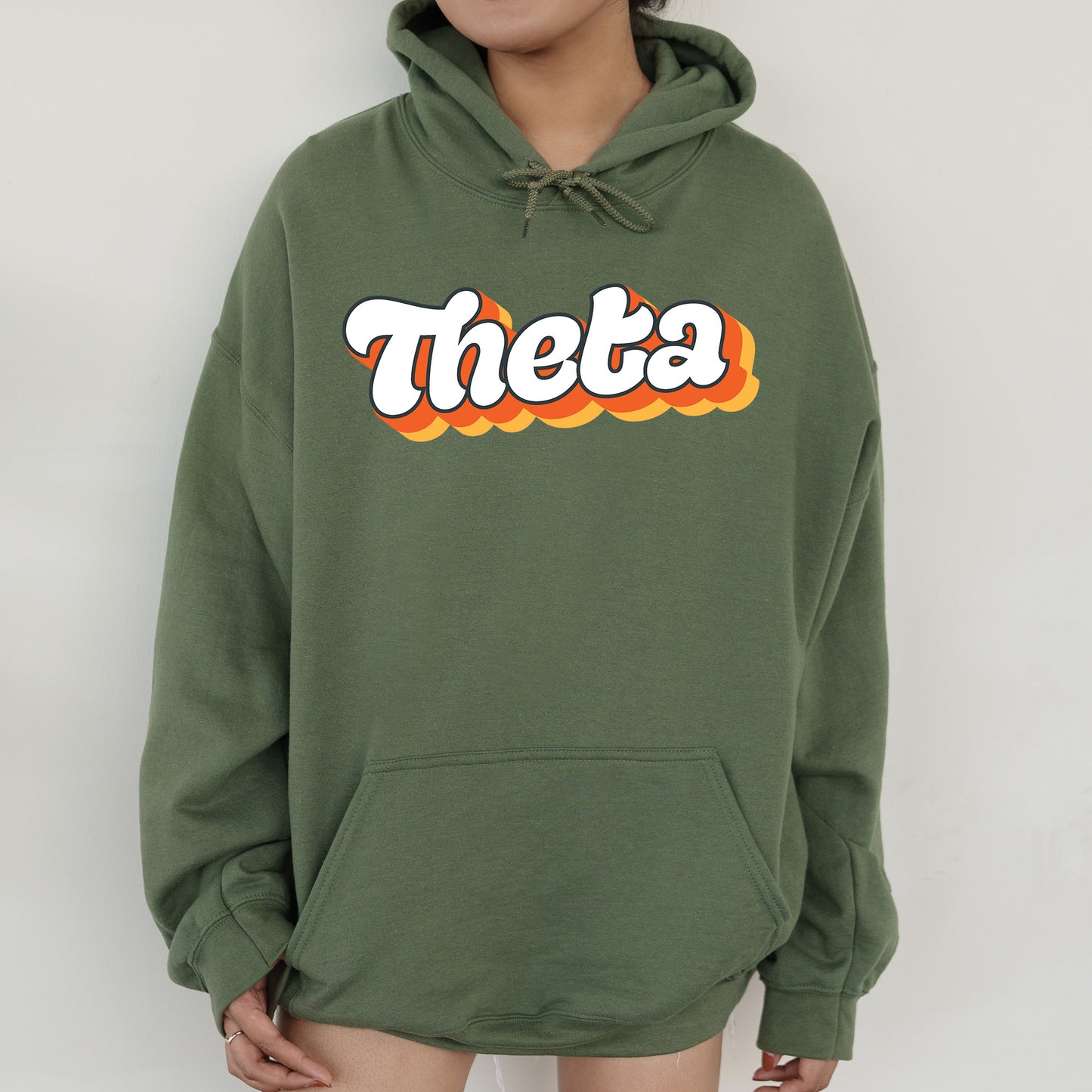 a person wearing a green hoodie with the word thea printed on it