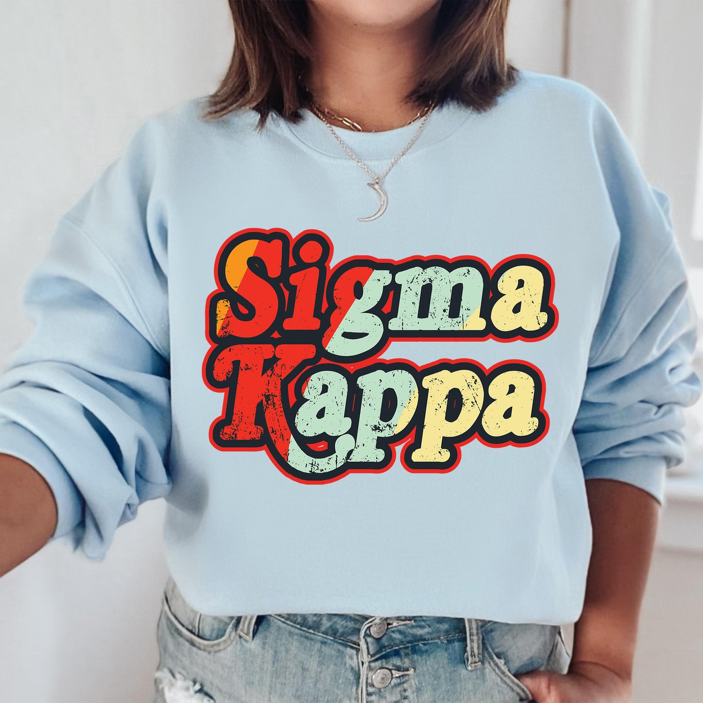 a woman wearing a blue sweatshirt with the word sima kappa on it