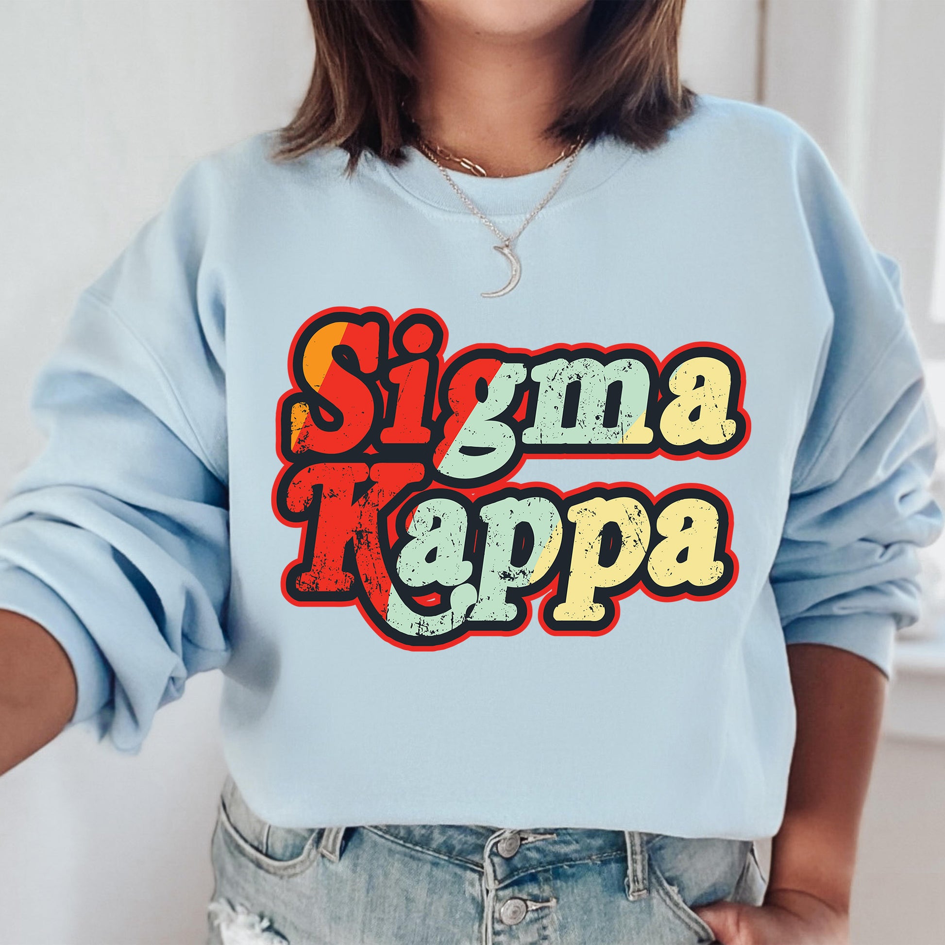 a woman wearing a blue sweatshirt with the word sima kappa on it