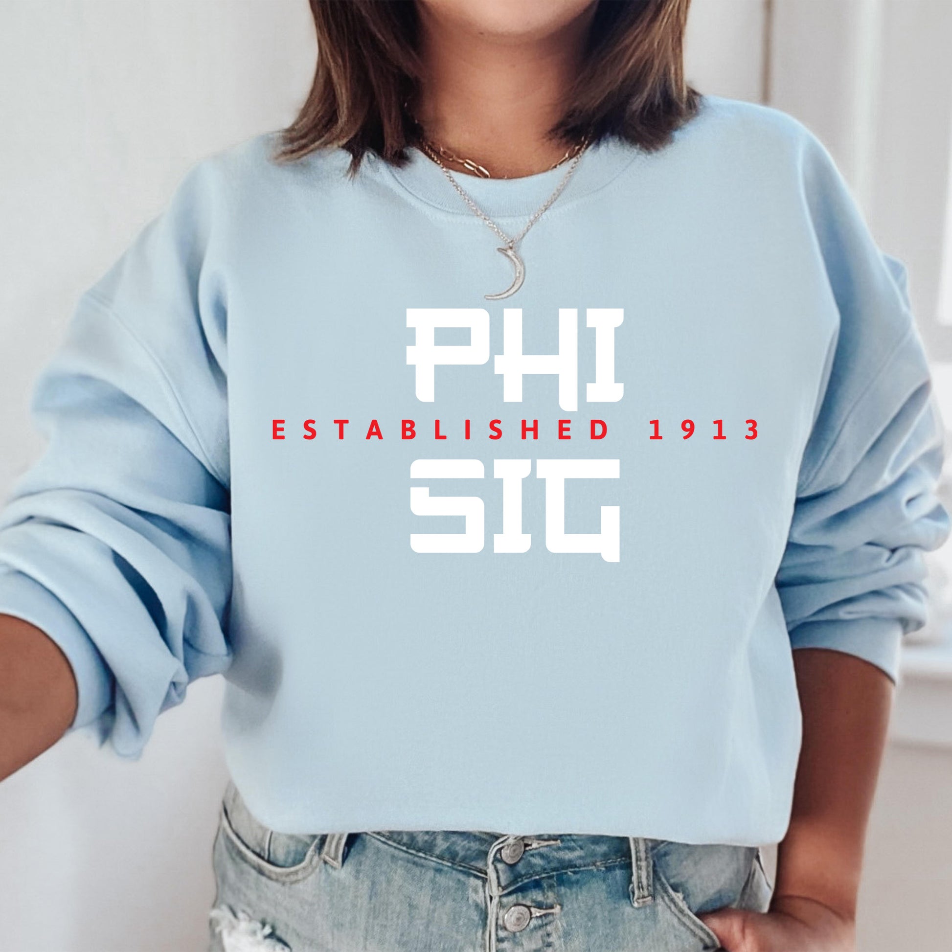 a woman wearing a sweatshirt that says phi established 1911