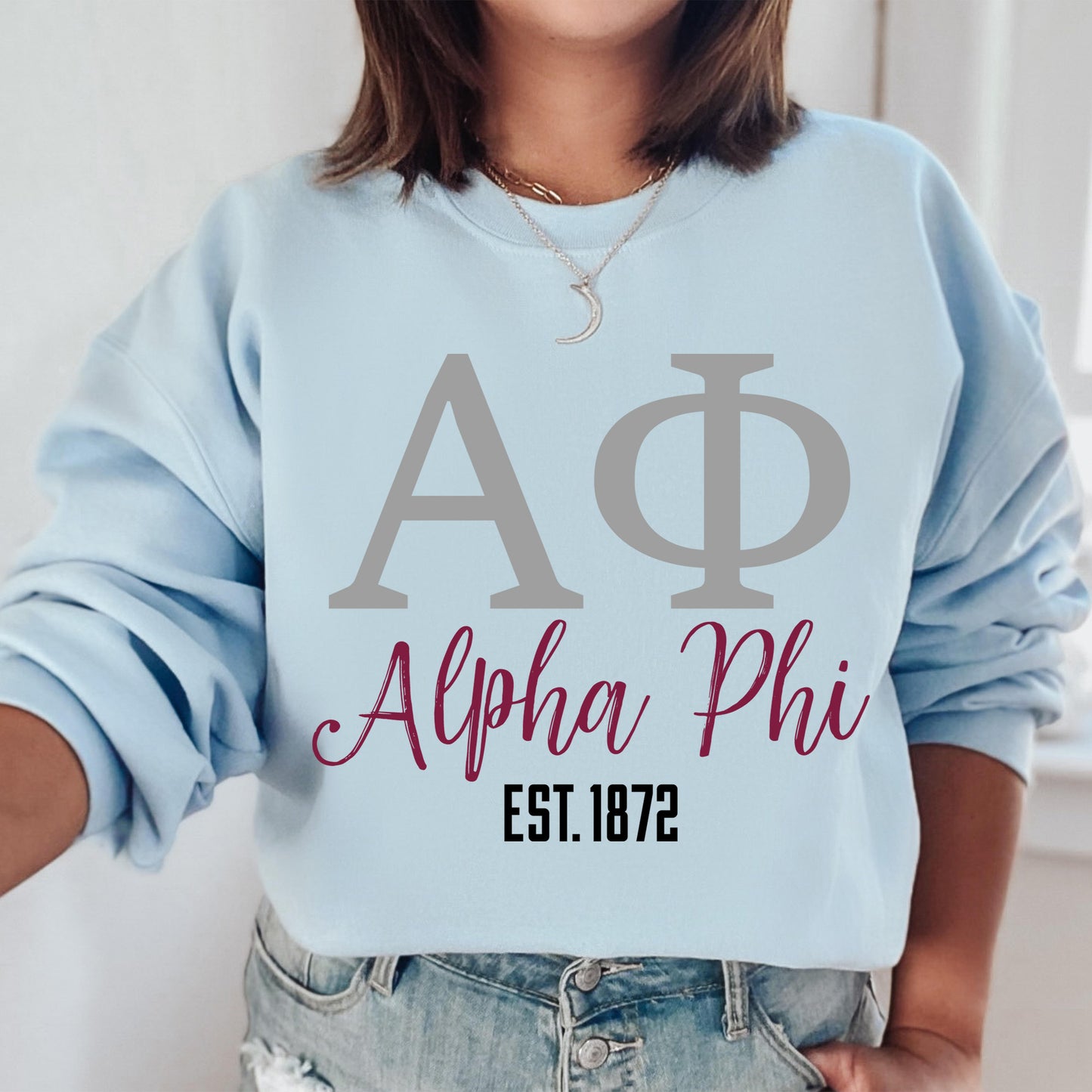 a woman wearing a blue sweatshirt with a phi phi on it