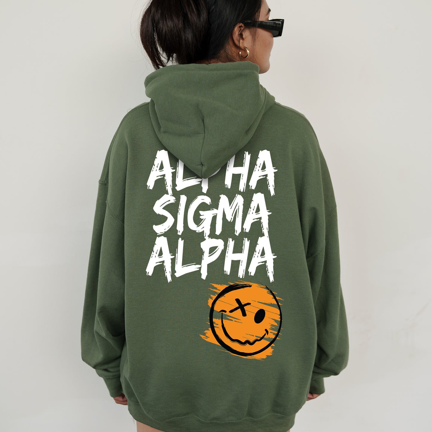 a woman wearing a green sweatshirt with a smiley face on it