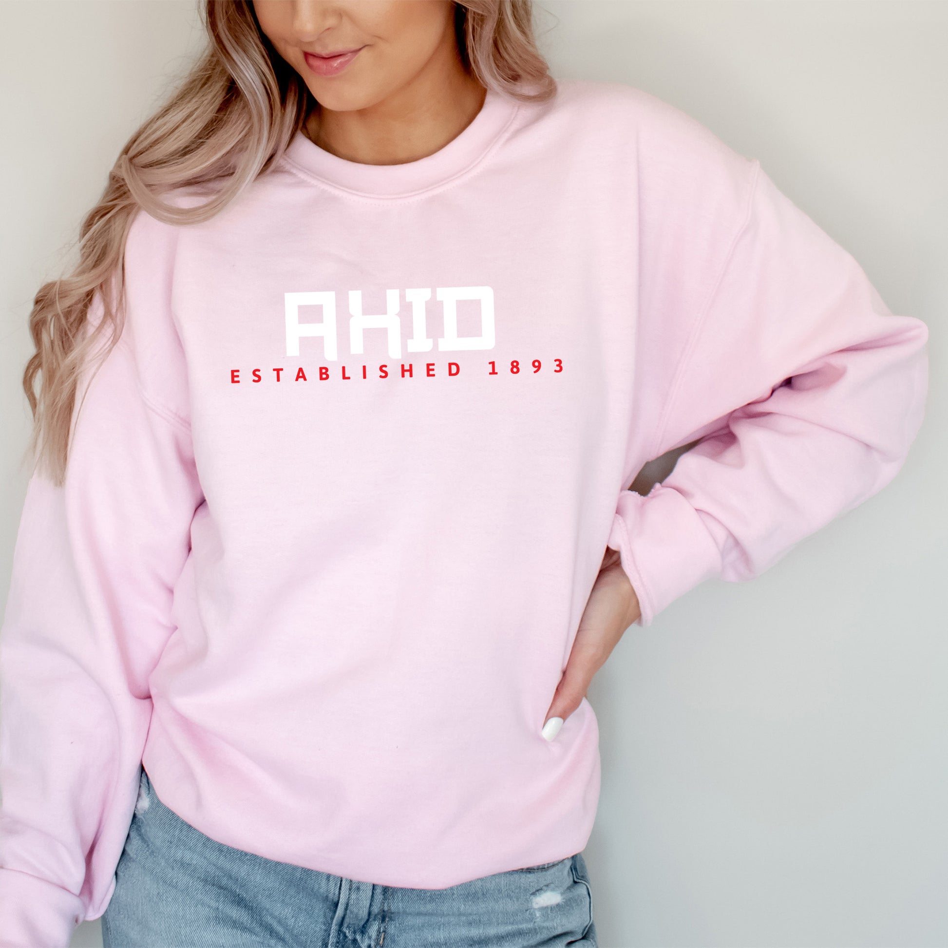 a woman wearing a pink sweatshirt and jeans