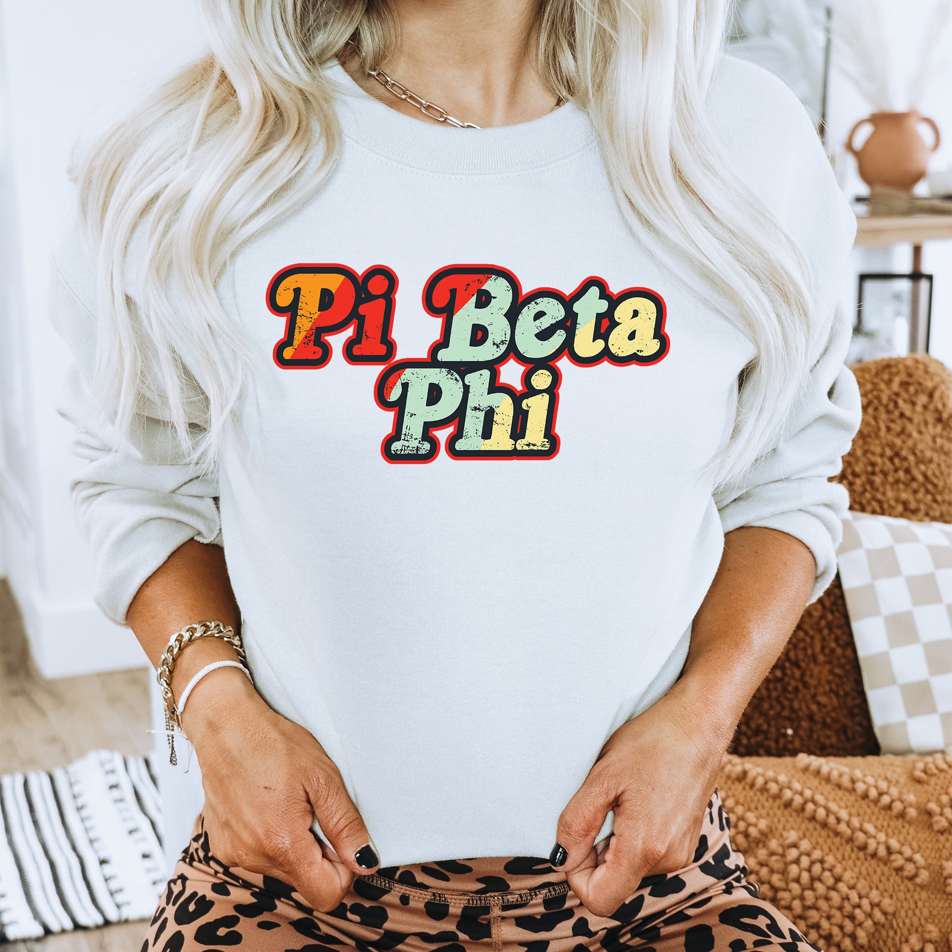 a woman with blonde hair wearing a white sweatshirt and leopard print pants