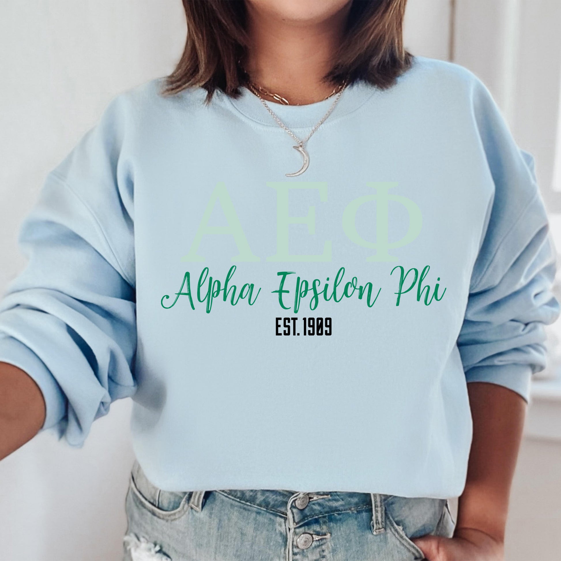 a woman wearing a blue sweatshirt with a green logo