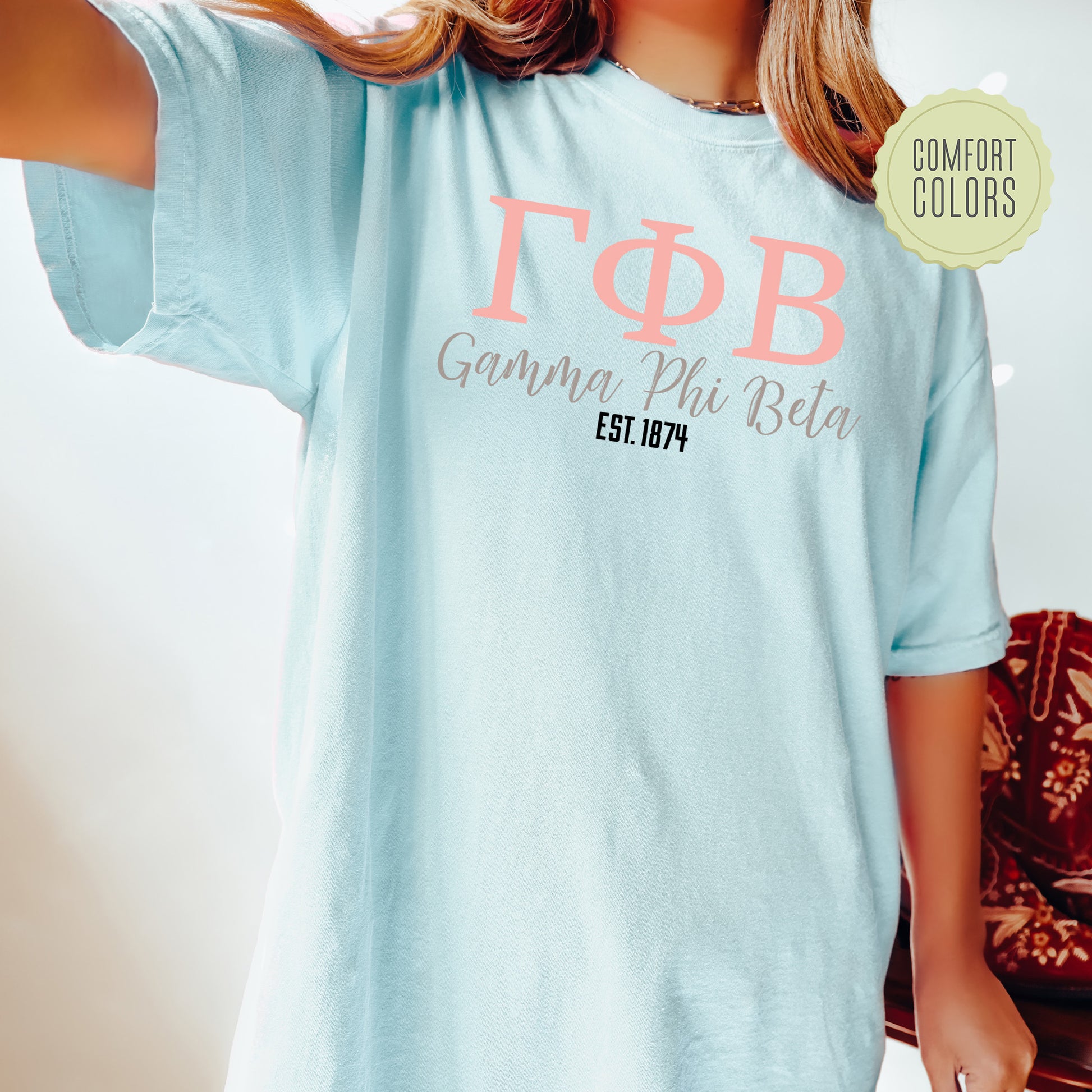 a woman wearing a light blue t - shirt with pink lettering