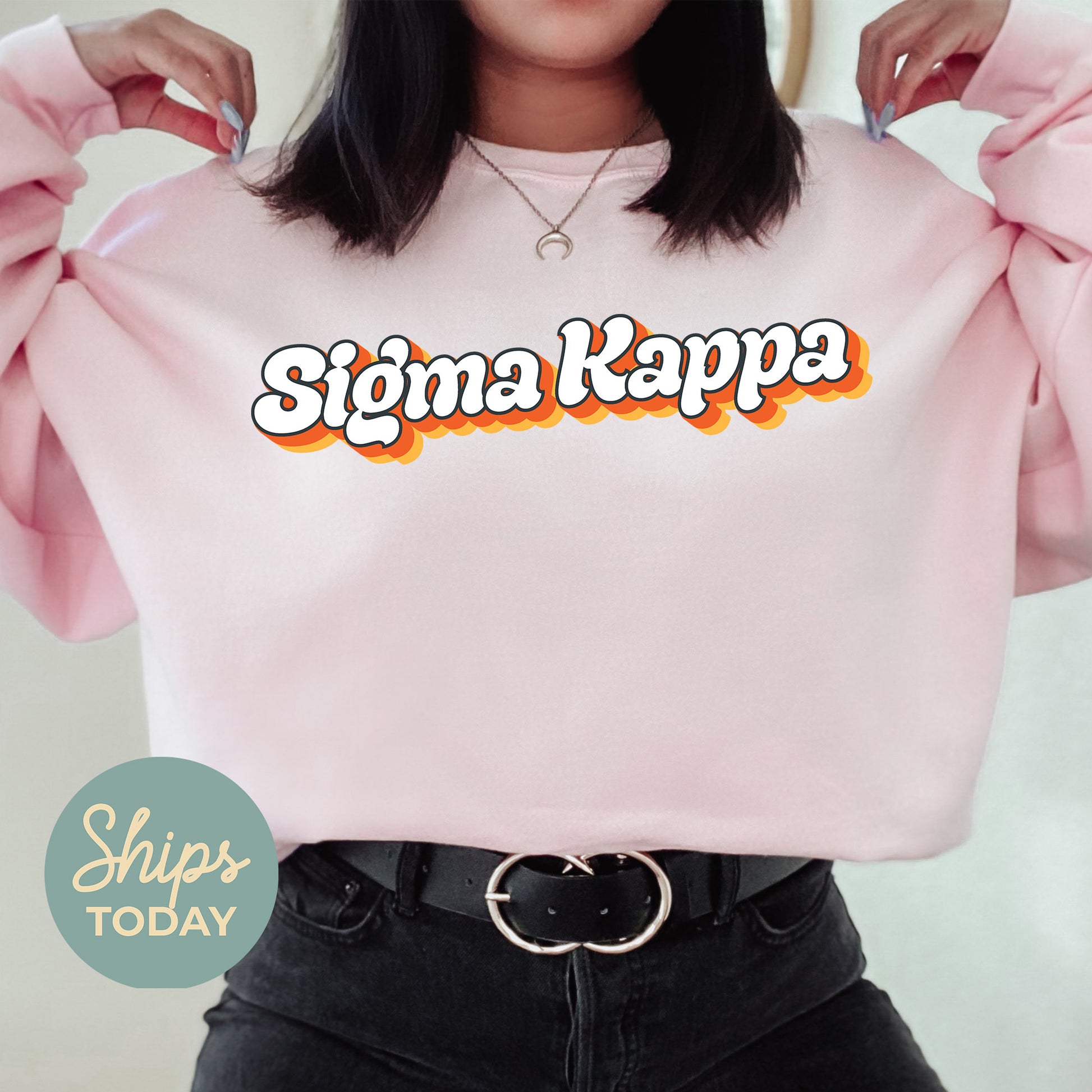 a woman wearing a pink sweater with the word stigma kapa on it