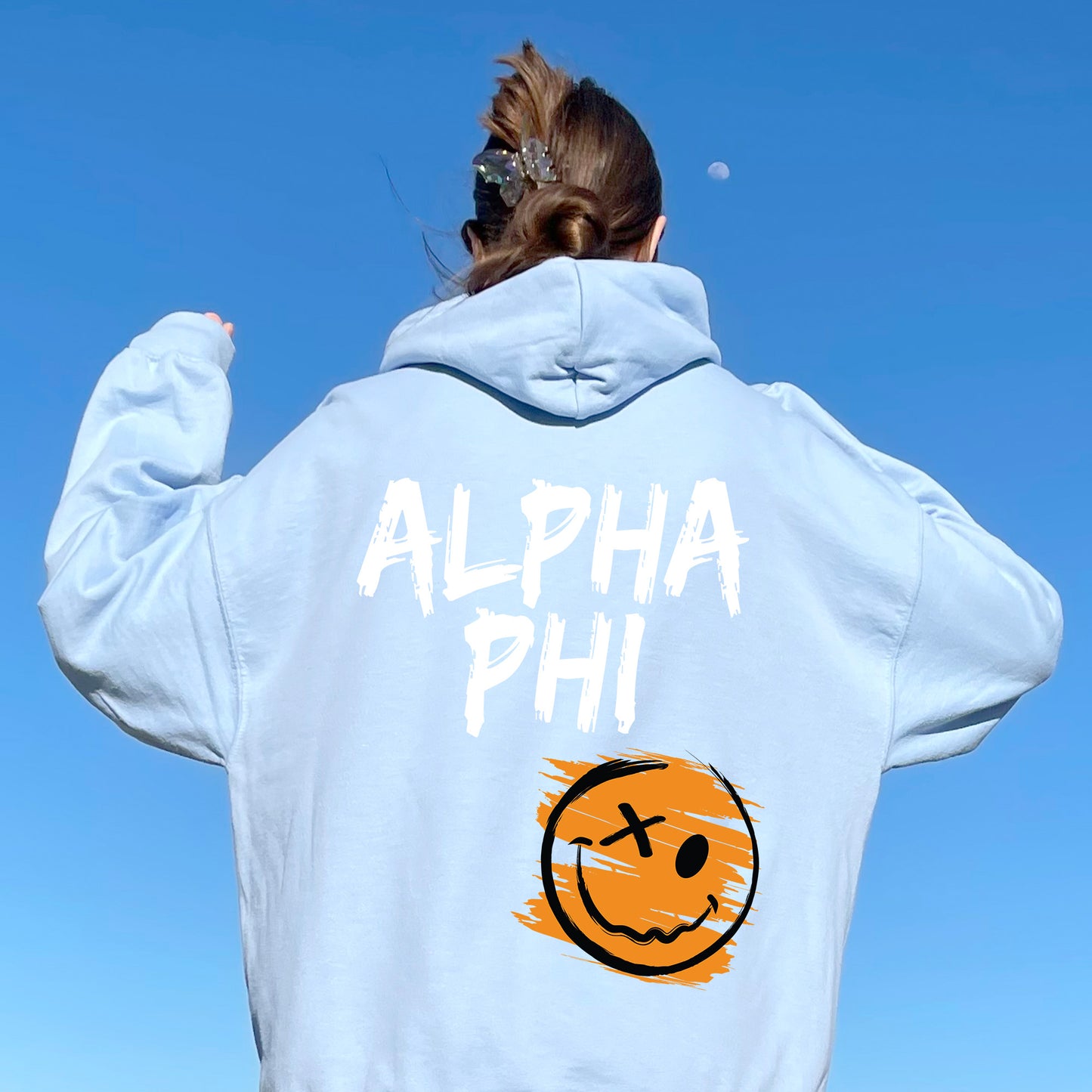 a woman wearing a sweatshirt with a smiley face on it