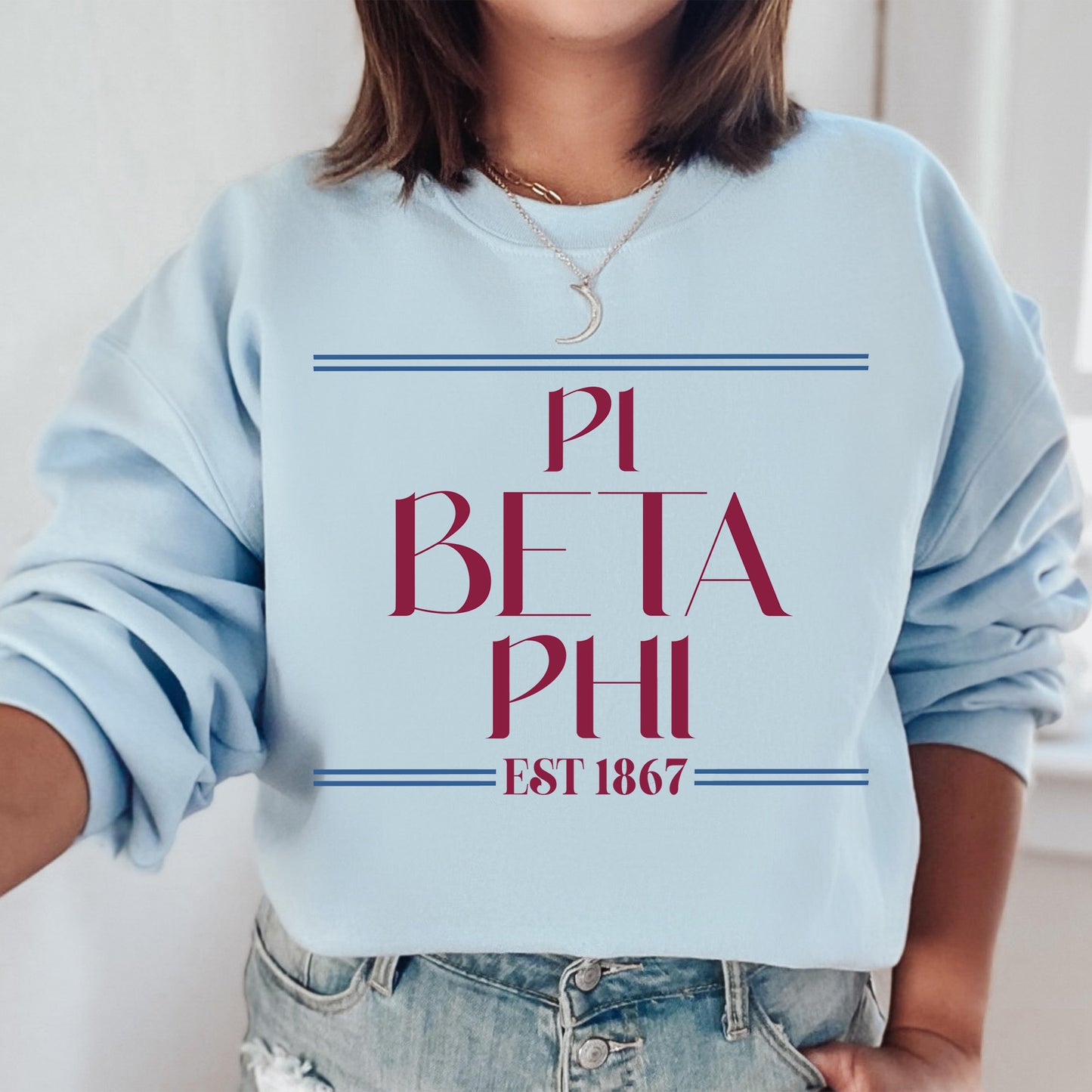 a woman wearing a blue sweatshirt with the words pi beta phi est 1876 printed