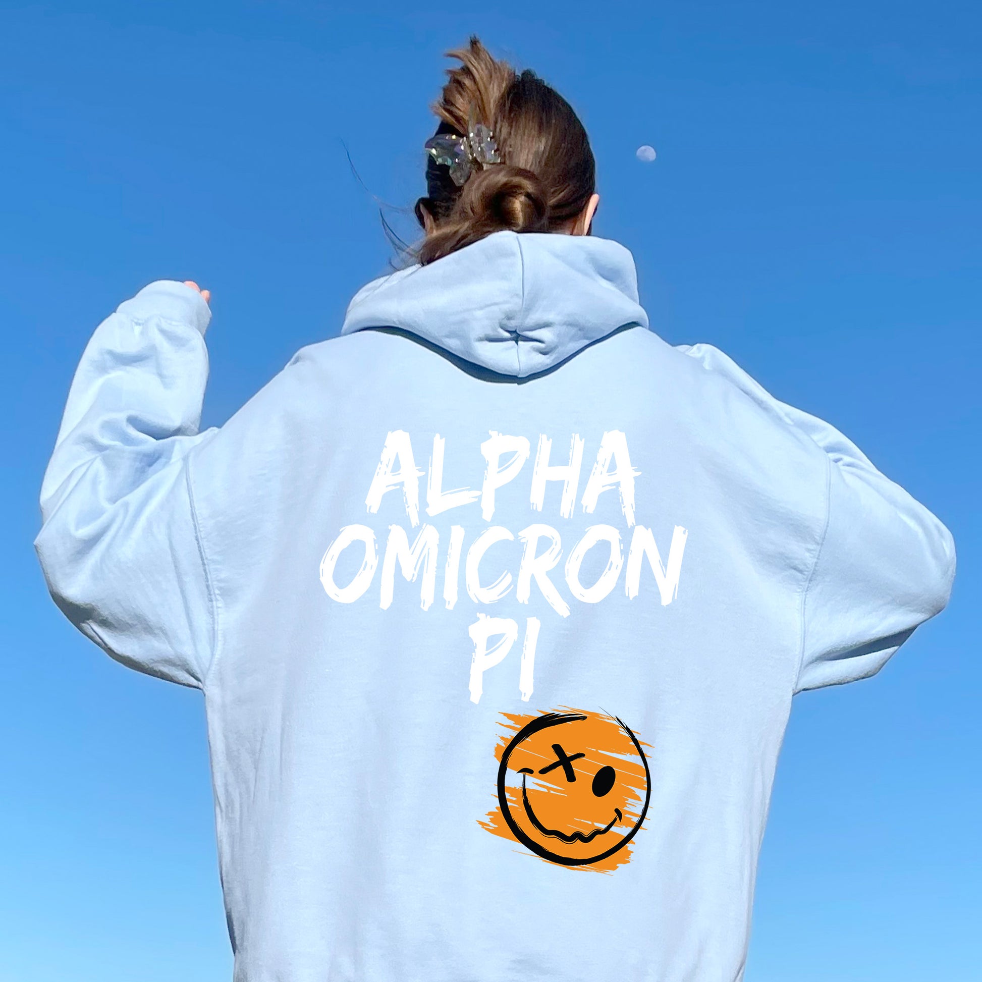 a woman wearing a sweatshirt with a smiley face on it