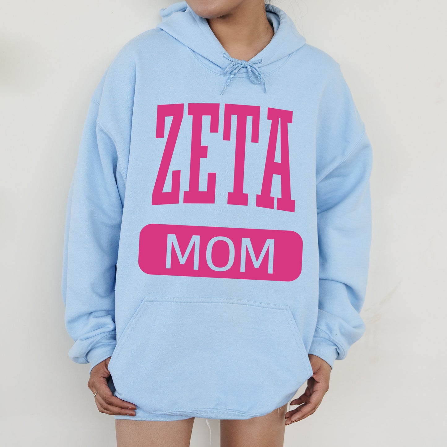 a woman wearing a blue hoodie that says zeta mom