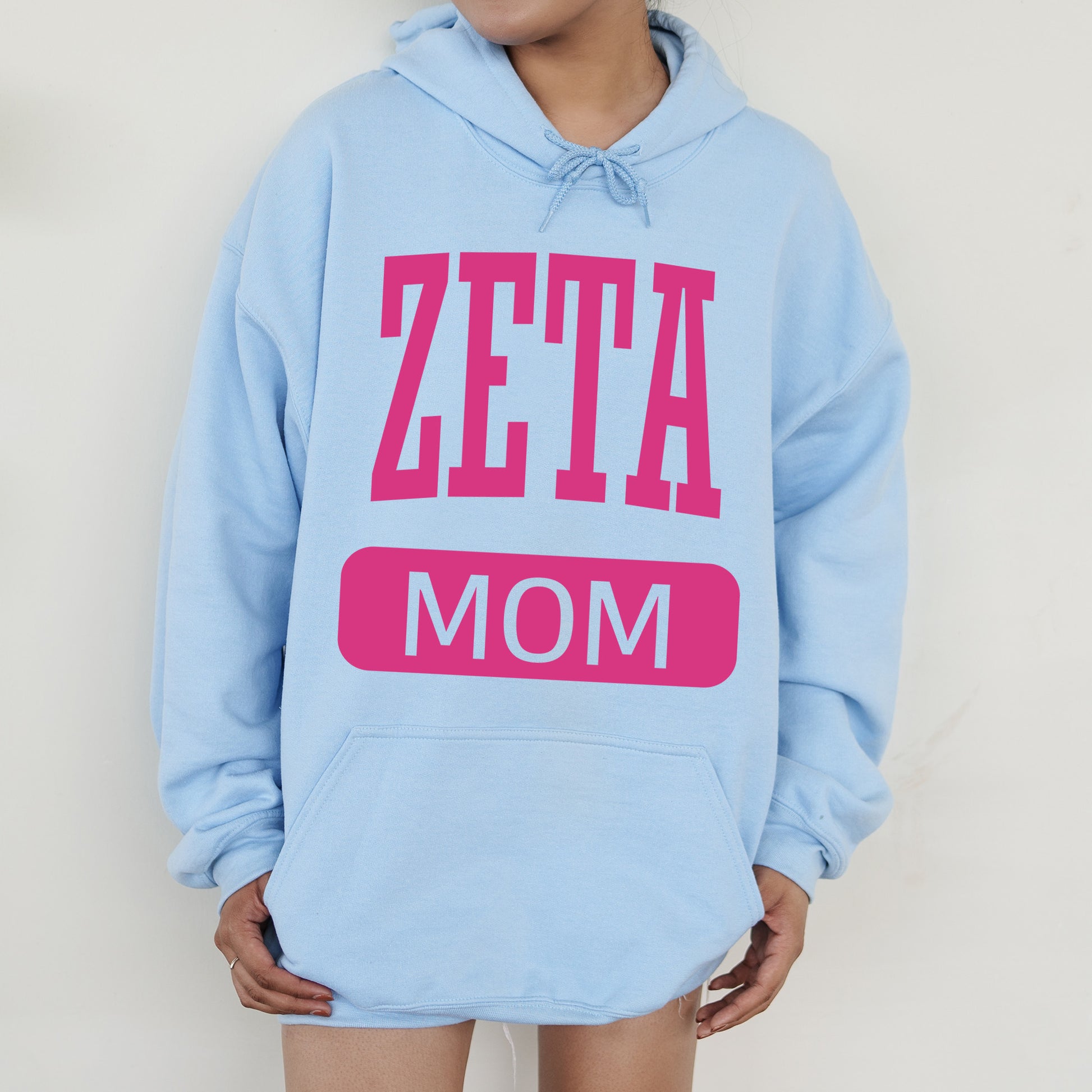 a woman wearing a blue hoodie that says zeta mom