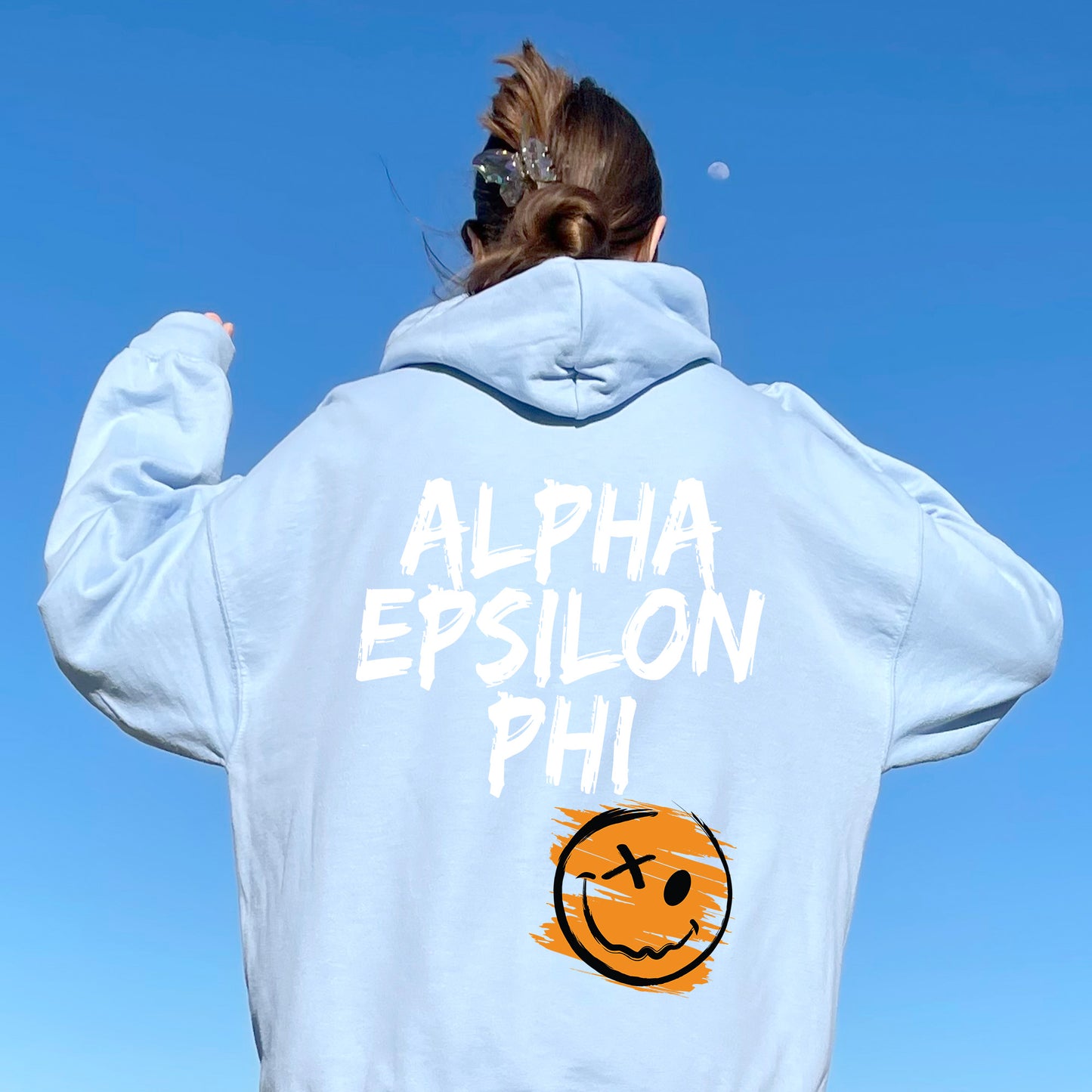 a woman wearing a sweatshirt with a smiley face on it