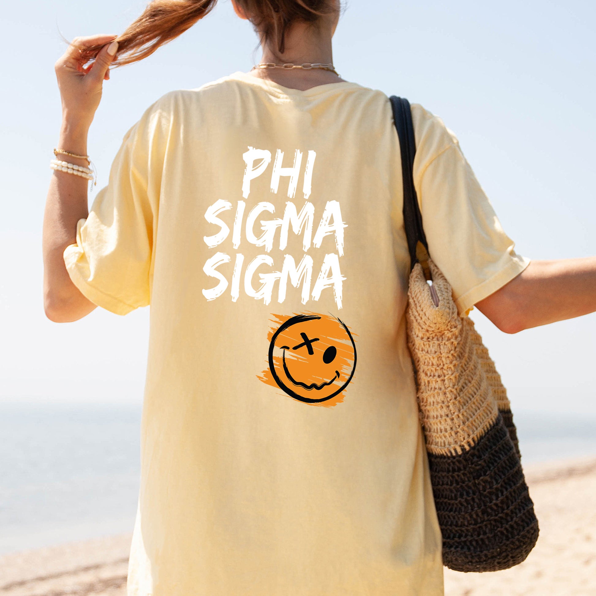 a woman walking on the beach with a smile on her shirt