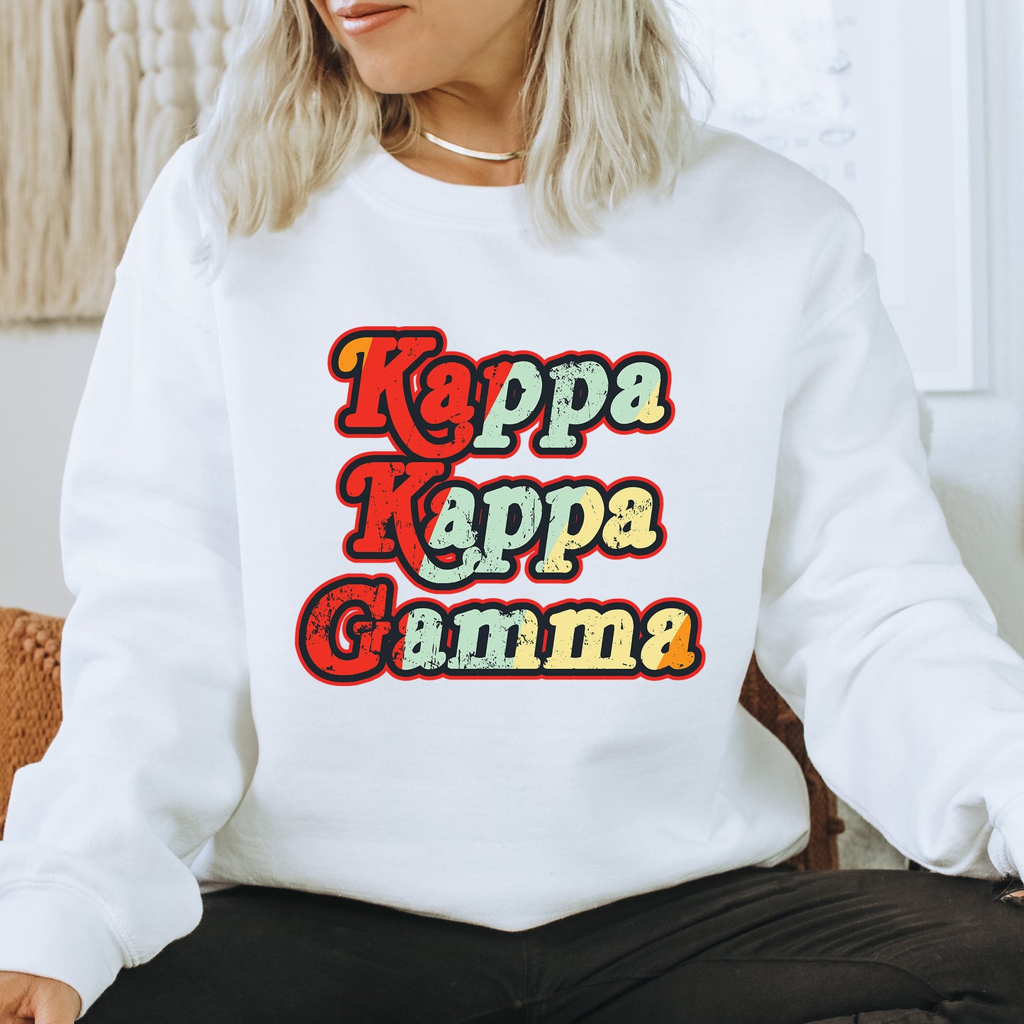 a woman sitting on a chair wearing a white sweatshirt with the words kapa ka