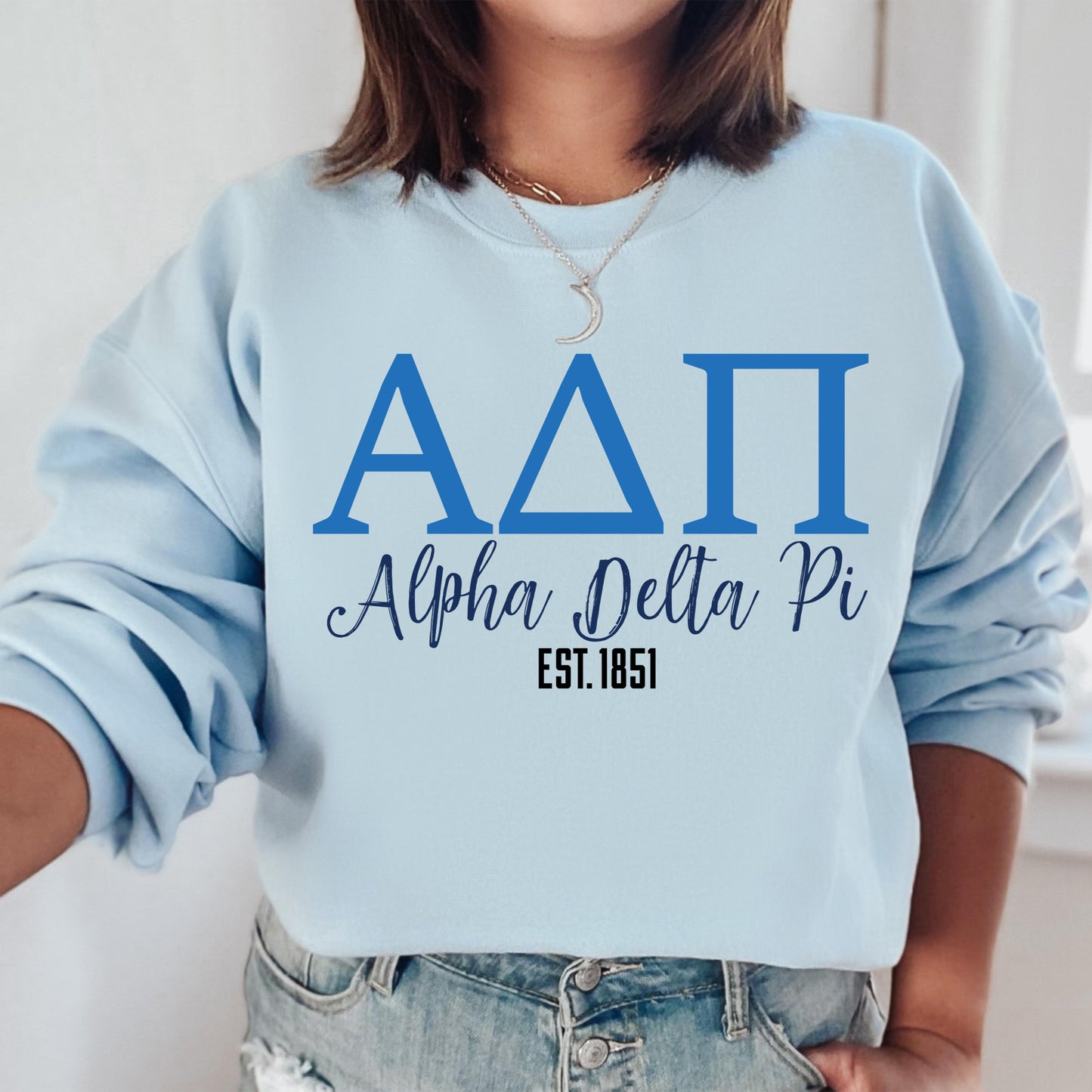 a woman wearing a blue sweatshirt with a delta pi on it