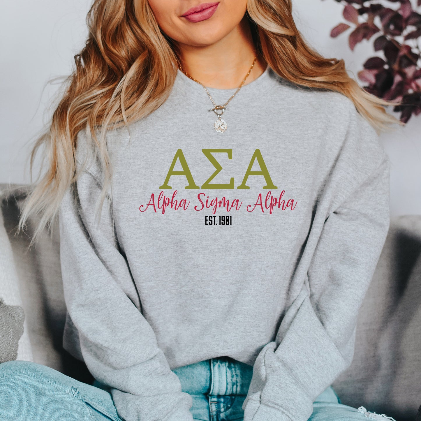 a woman sitting on a couch wearing a sweatshirt