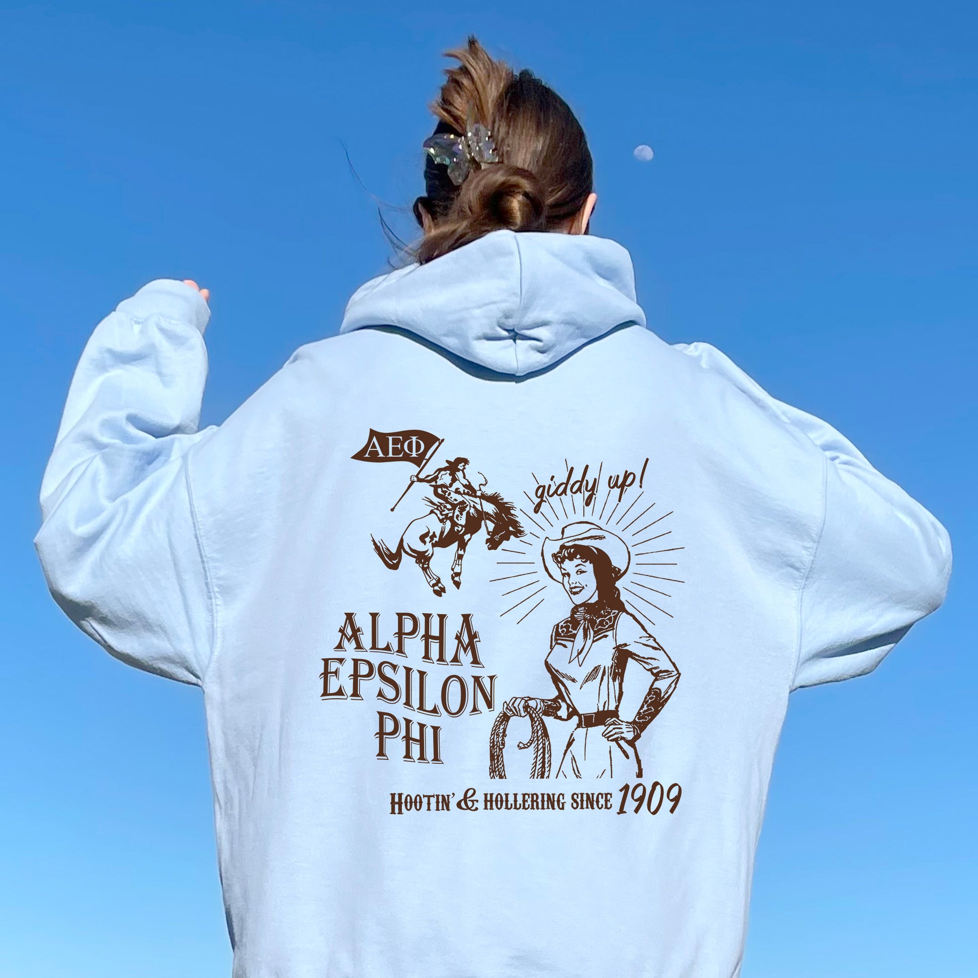 a woman in a white hoodie is flying a kite