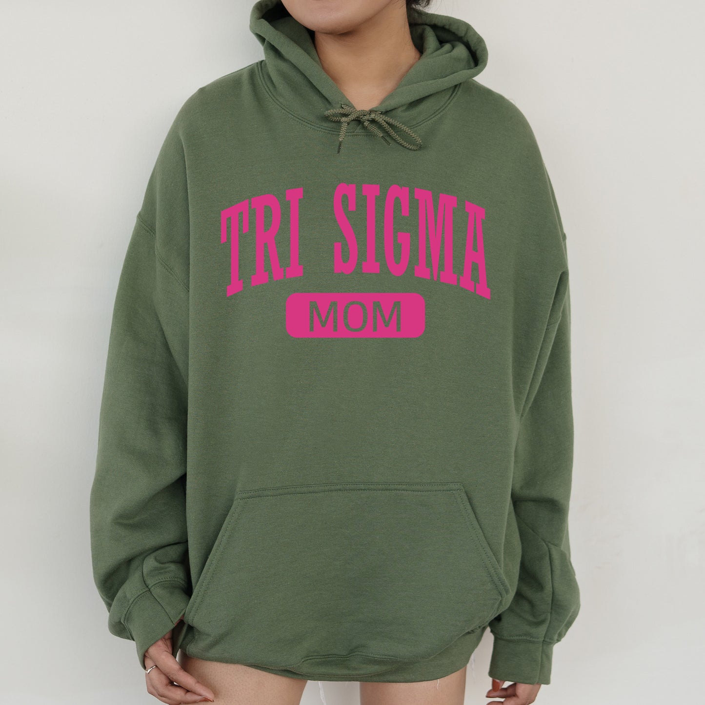 a woman wearing a green hoodie with the word tri stigma on it