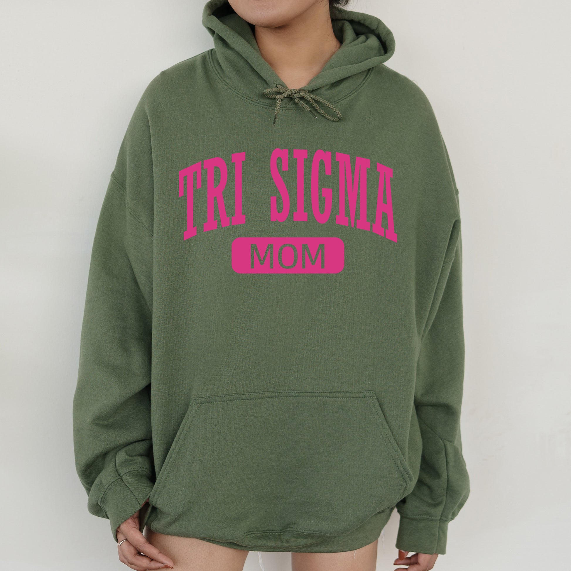 a woman wearing a green hoodie with the word tri stigma on it