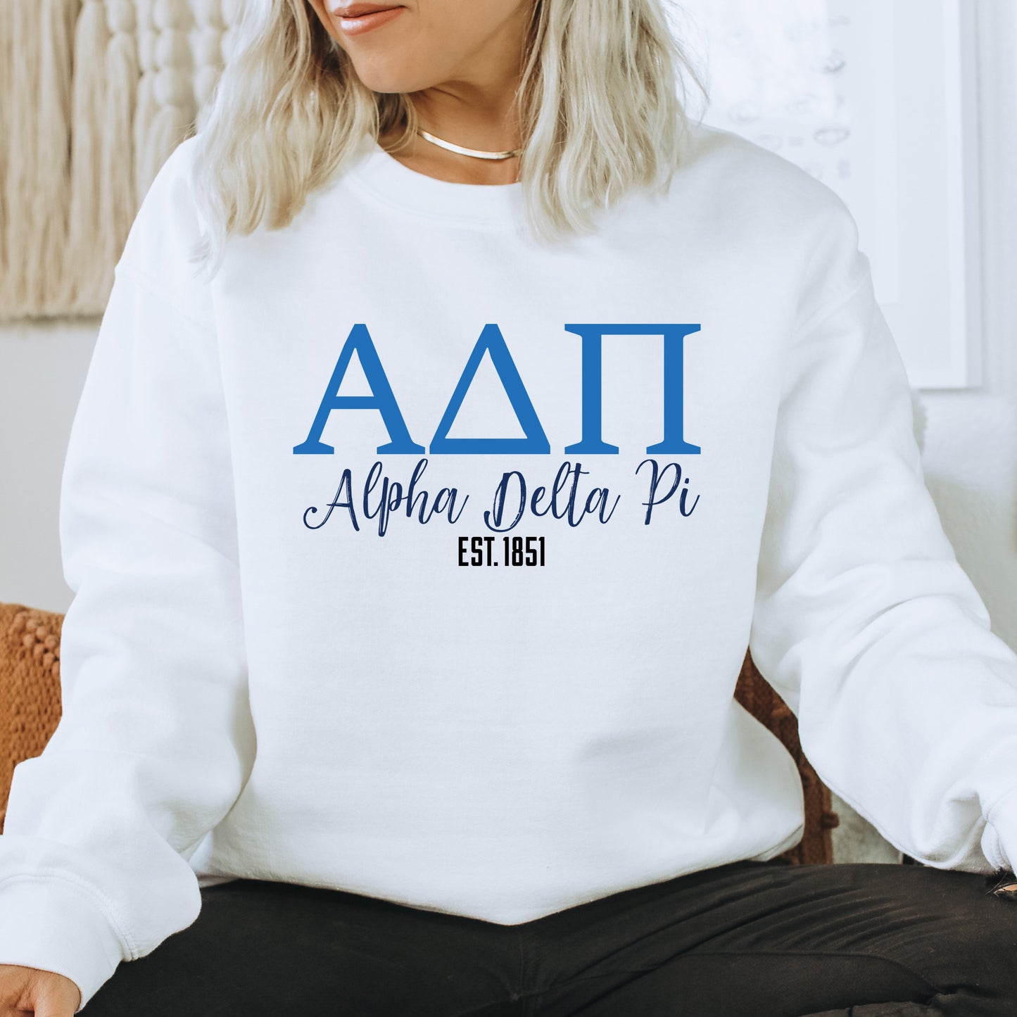 a woman sitting on a chair wearing a white sweatshirt