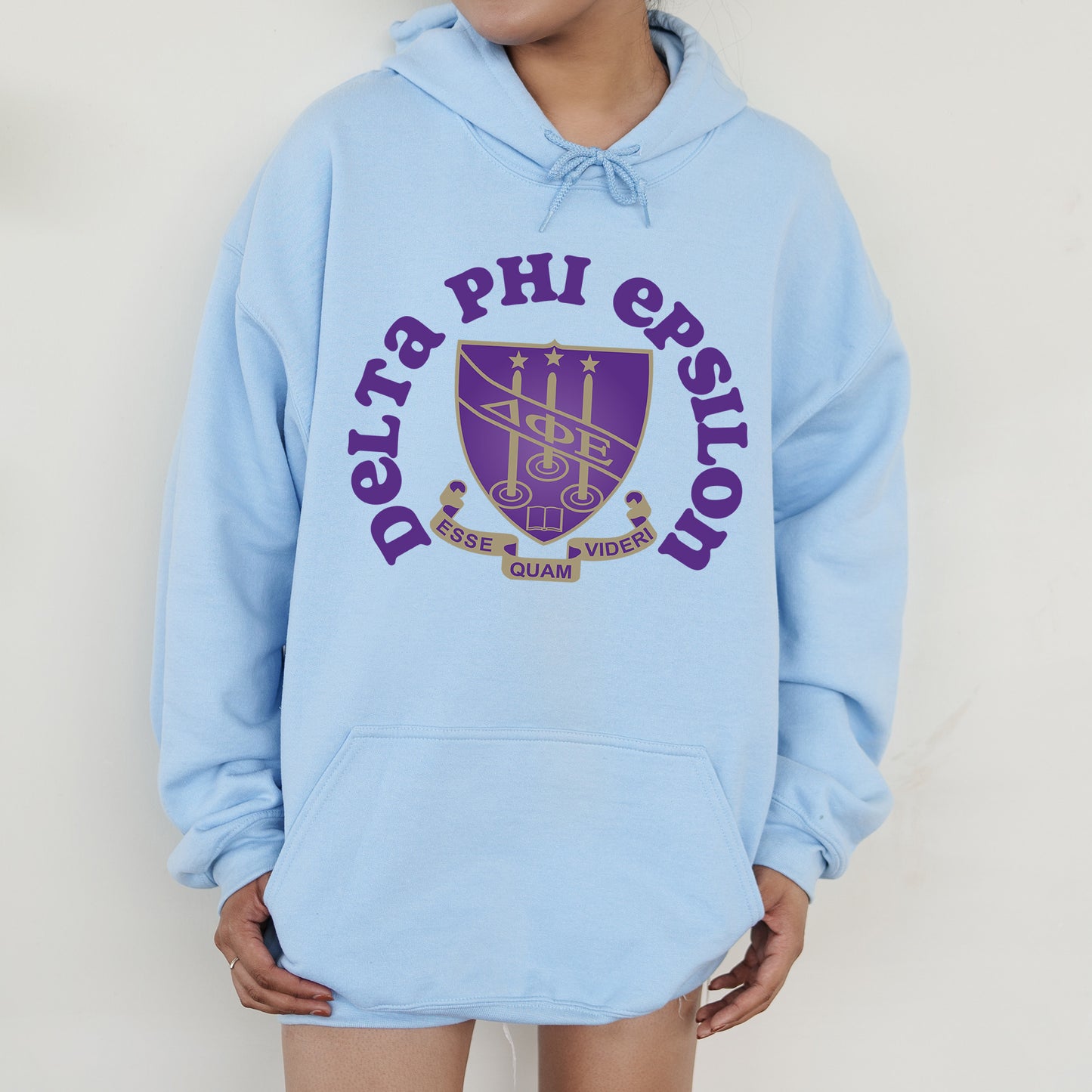 a person wearing a blue hoodie with a purple logo