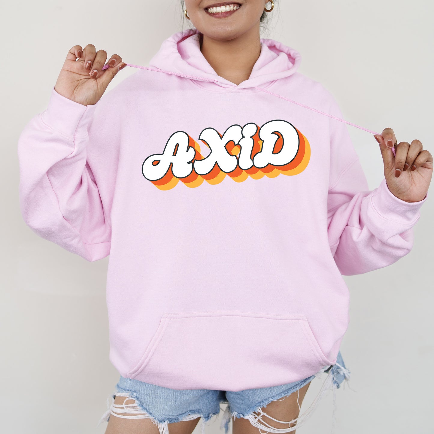 a woman wearing a pink hoodie with the word acid on it