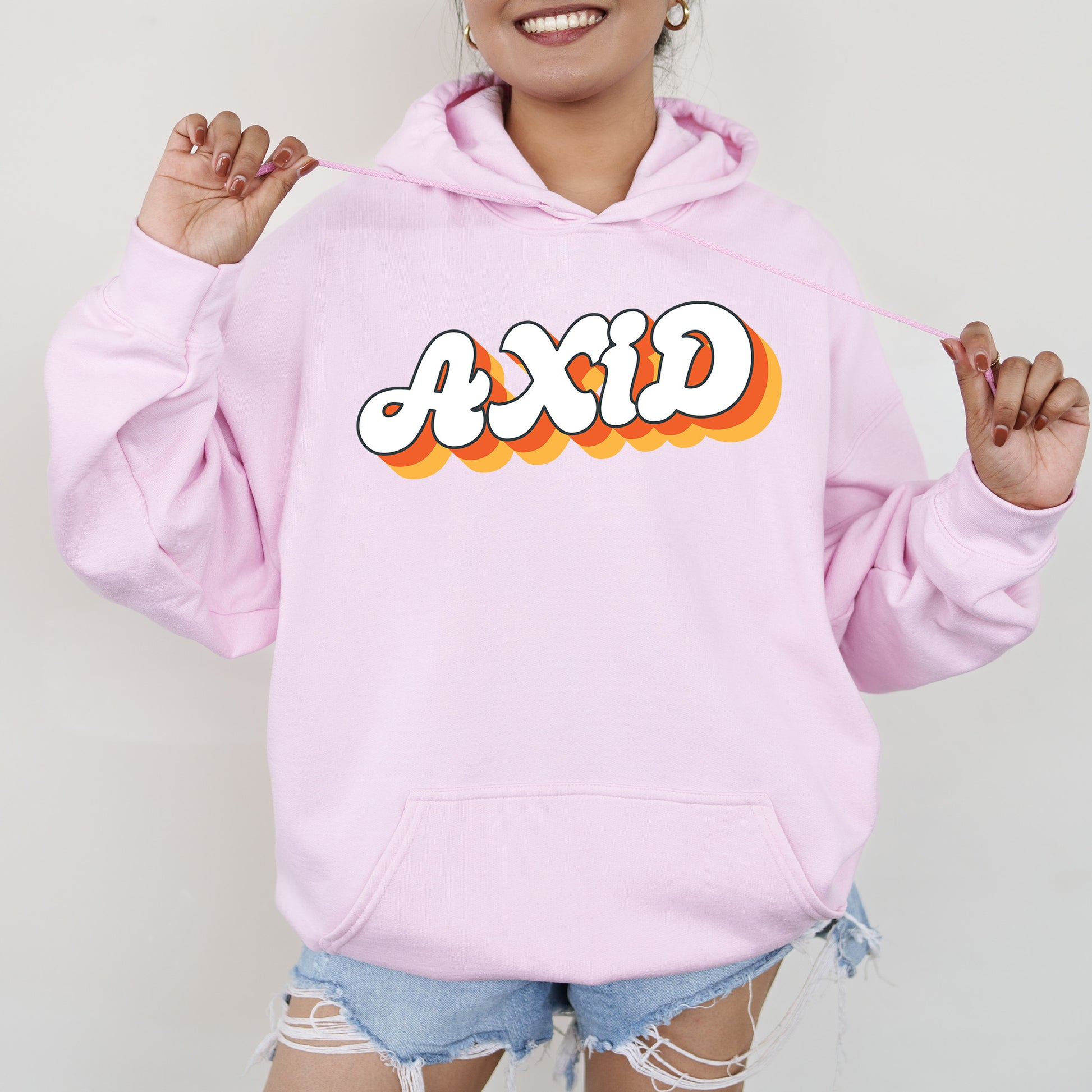 a woman wearing a pink hoodie with the word acid on it