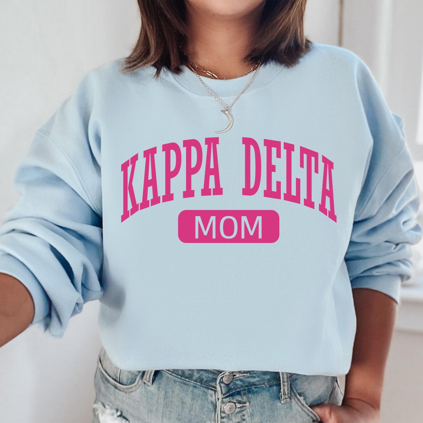 a woman wearing a sweatshirt that says kappa delta mom