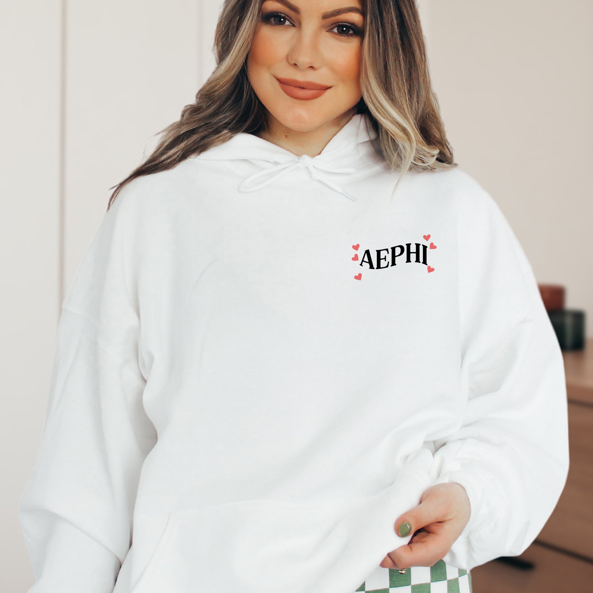 a woman wearing a white hoodie with a checkerboard pattern