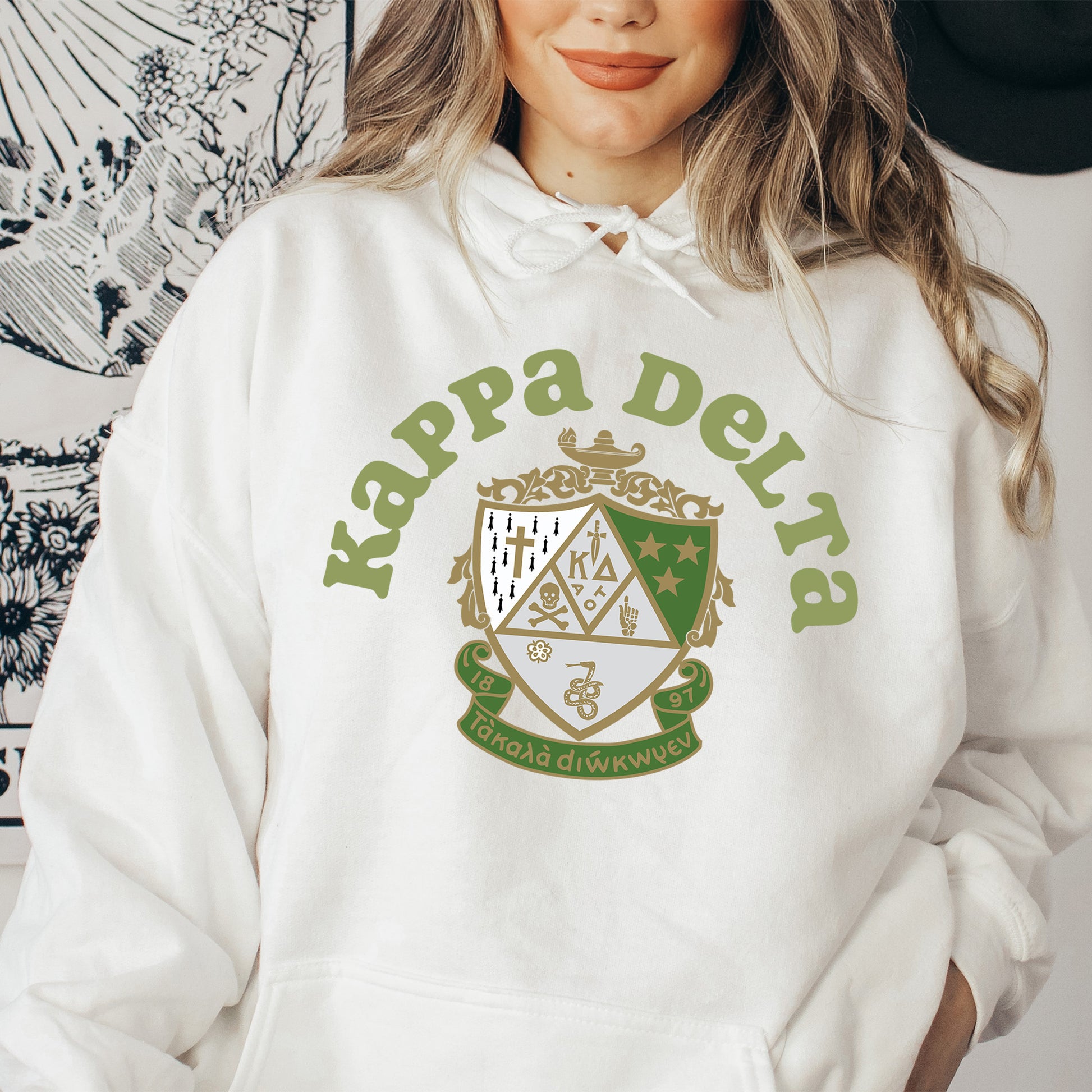 a woman wearing a white hoodie with a green and gold crest on it