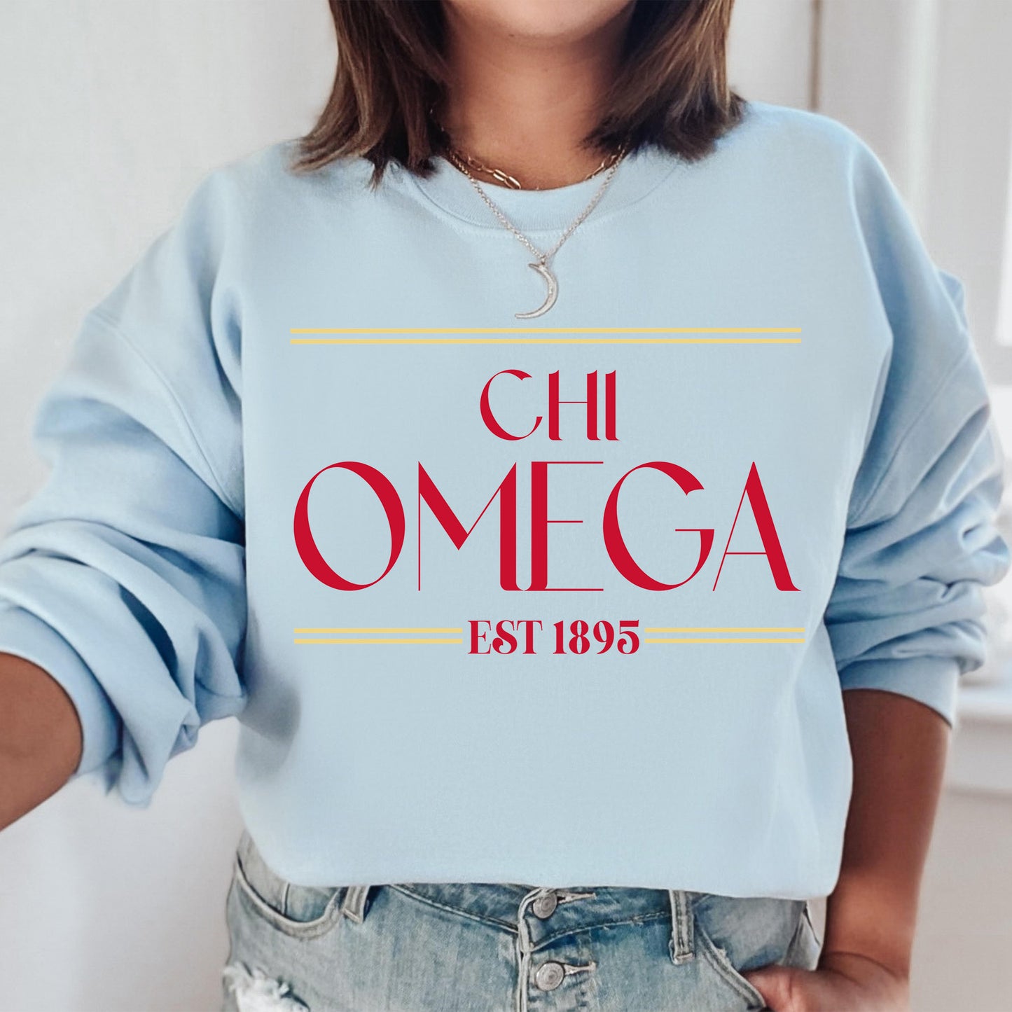 a woman wearing a blue sweatshirt with the words chi omega printed on it