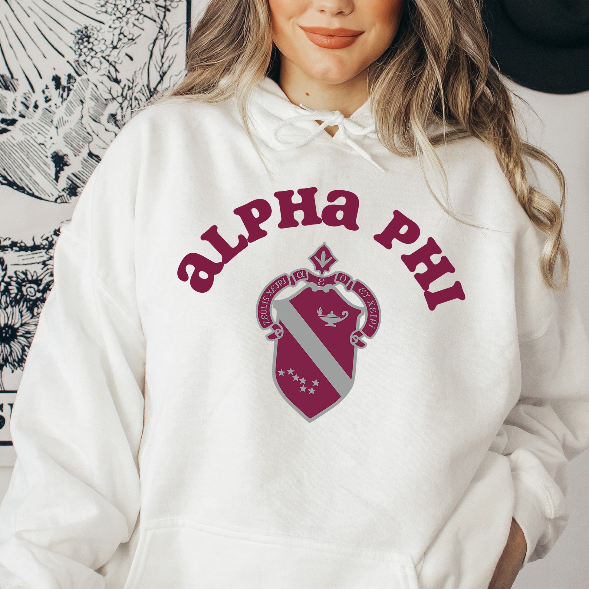 a woman wearing a white hoodie with a red and white crest on it