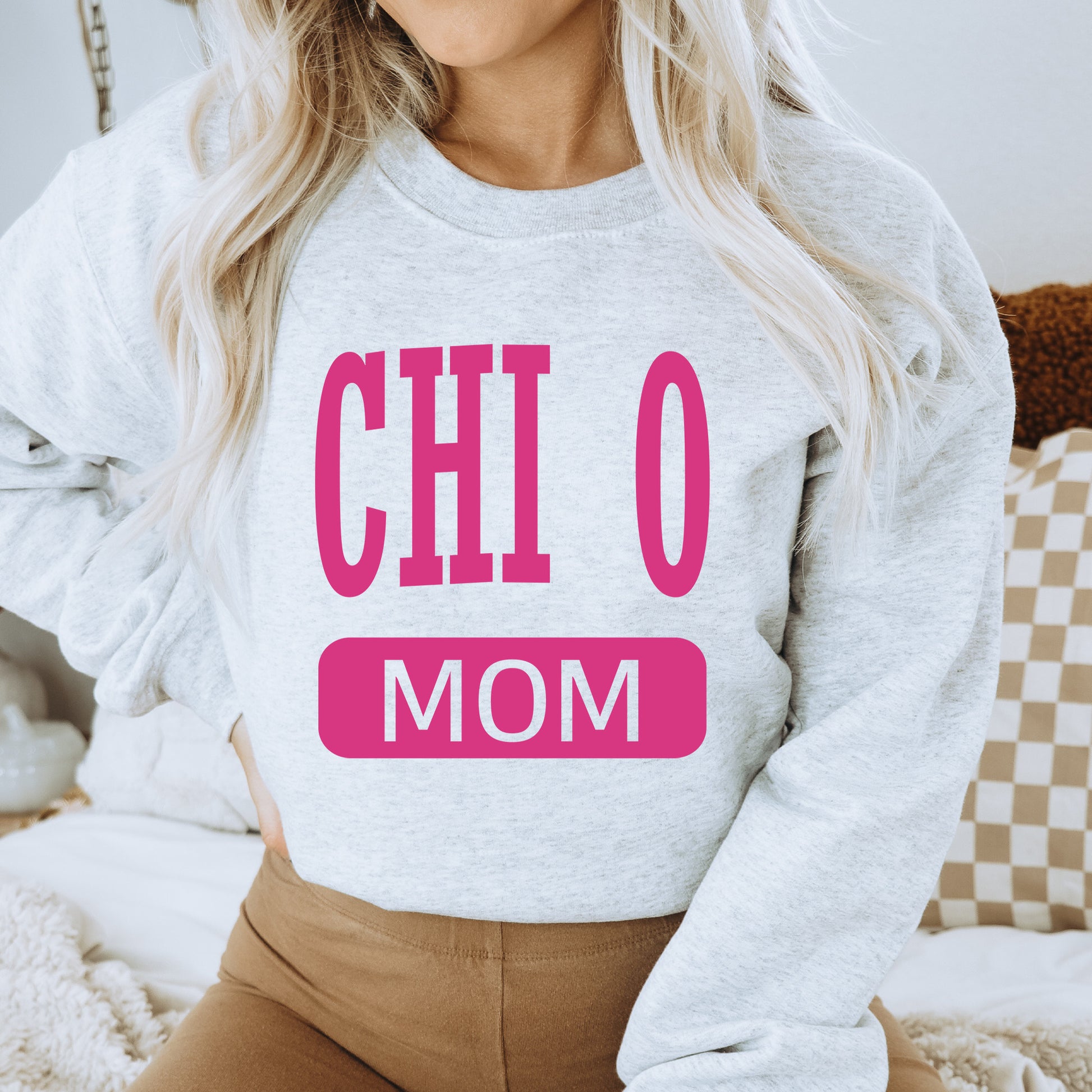 a woman wearing a sweatshirt that says chio mom