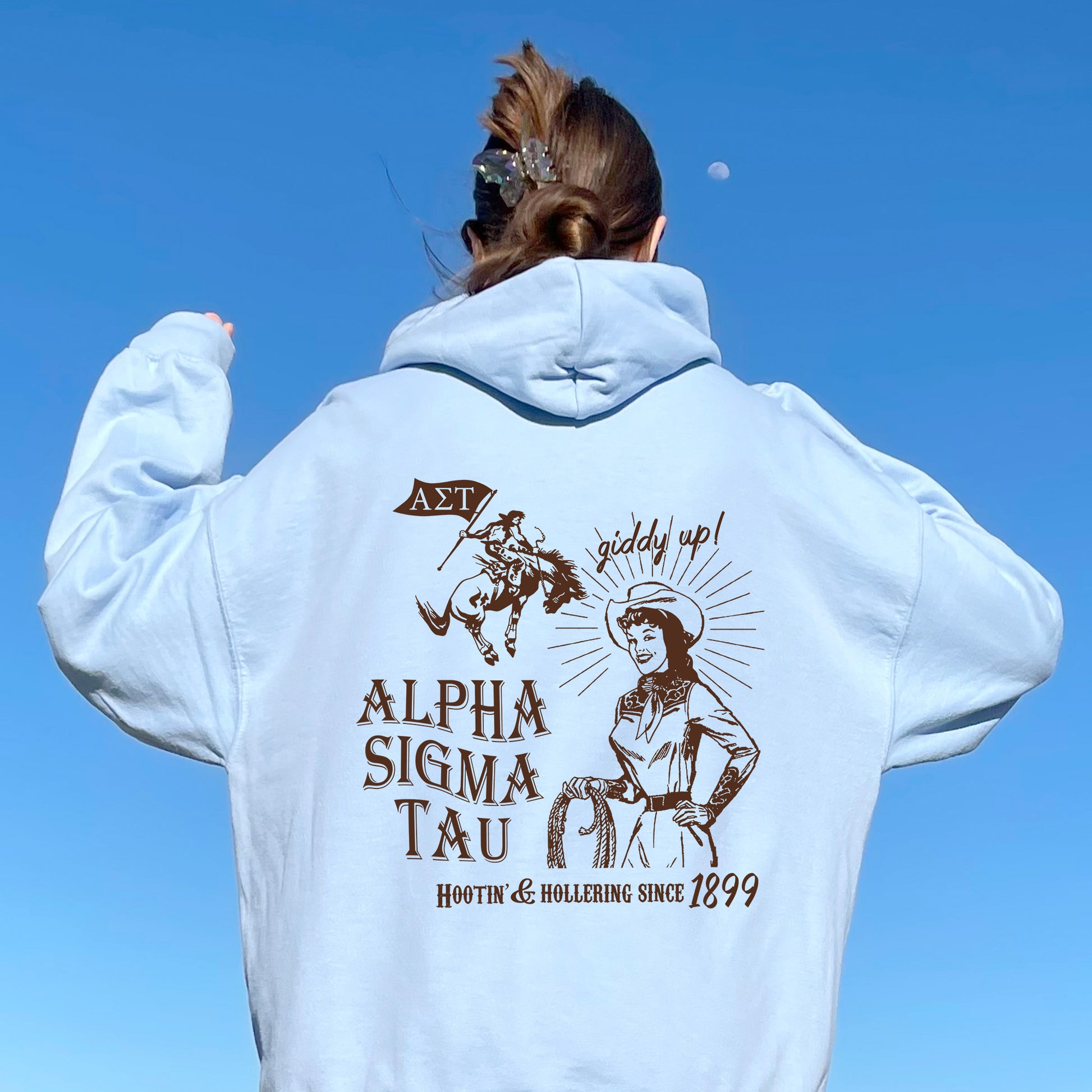 a woman in a white hoodie is flying a kite